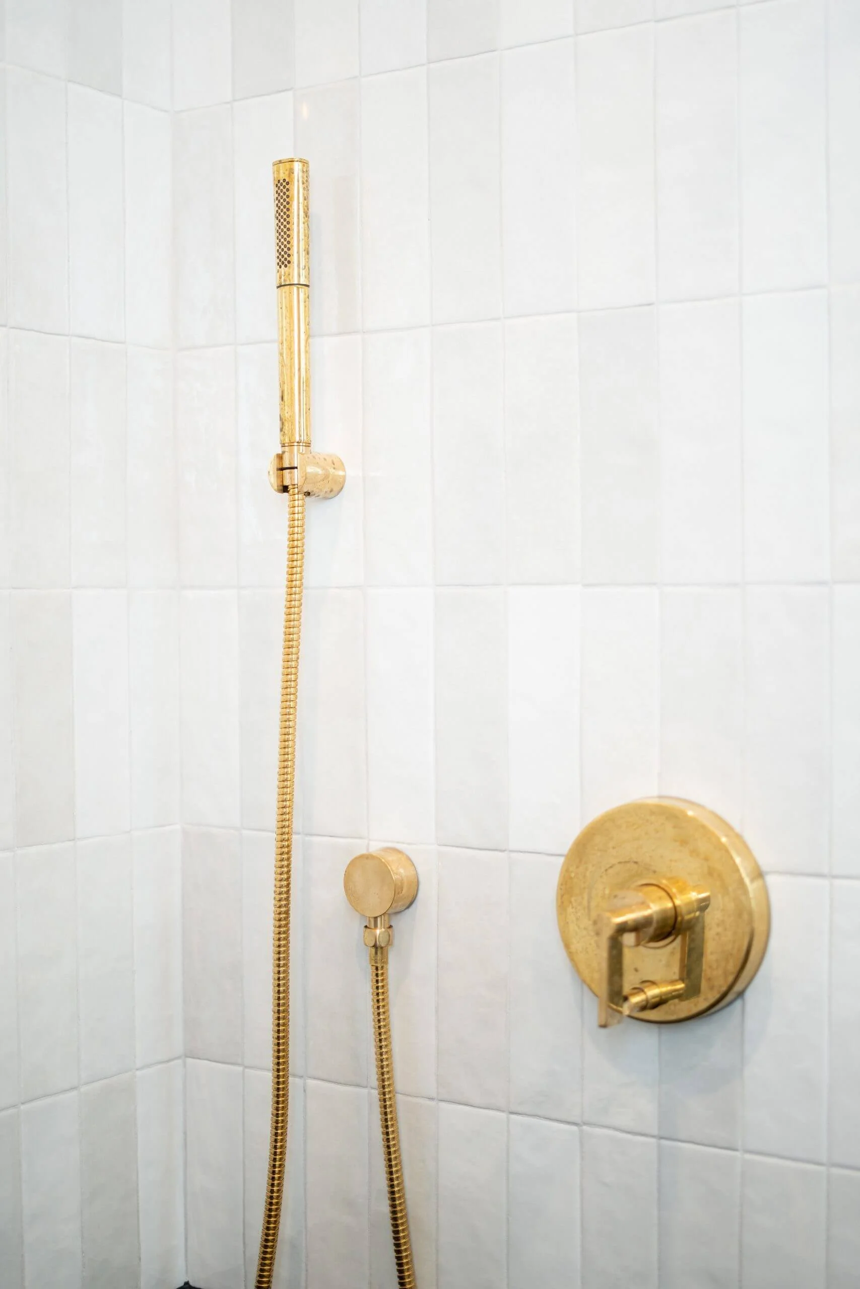 Sussex brushed brass hand shower and vertical white finger tiles in Toorak luxury bathroom