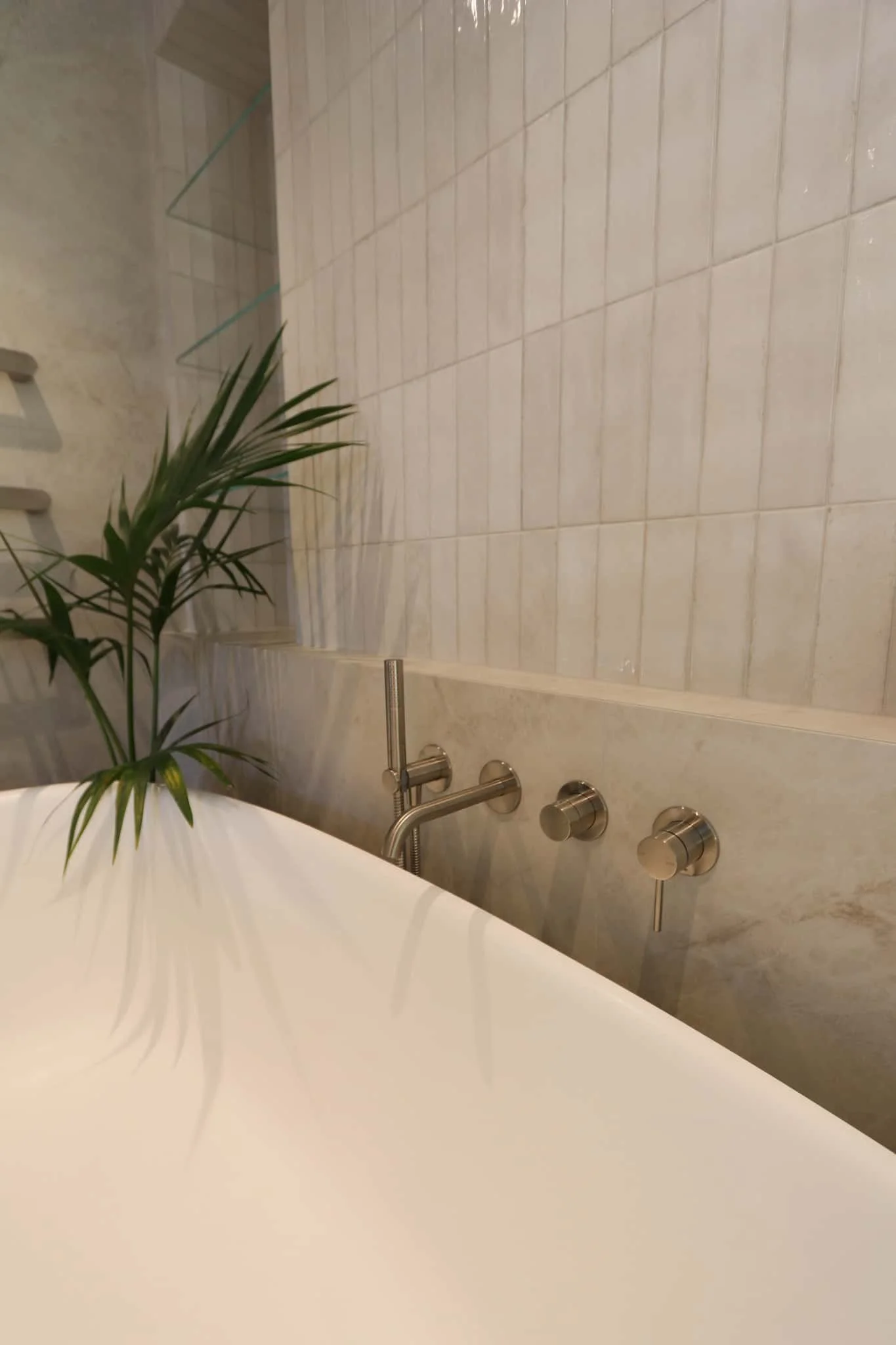 Close up of a freestanding bathtub with wall-mounted brushed nickel tapware in a Strathmore renovation