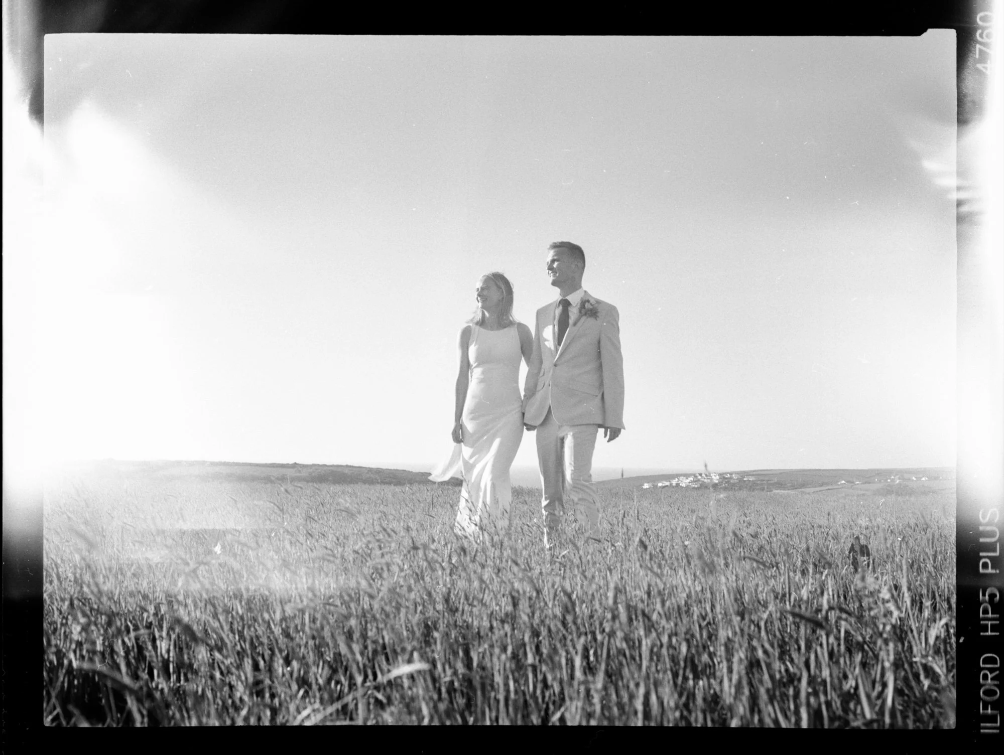 A collection of filmstrip-style photos showing various scenes including a dance party with people dancing and mingling, a couple kissing outdoors at night, and a child playing with toys indoors. Some photos depict people in festive attire enjoying an event in a tent with string lights, while others show night scenes with a backdrop of dark skies.