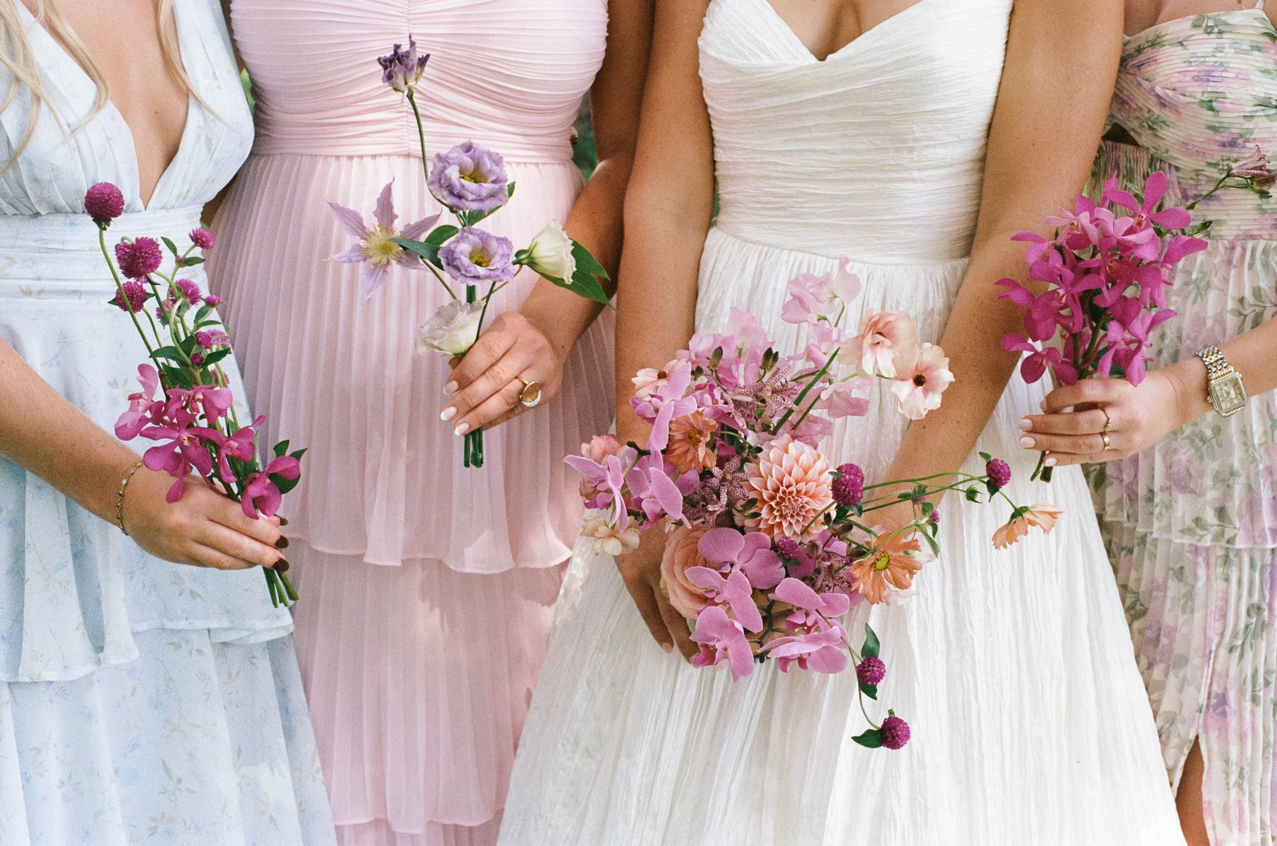 Close-up of women in pastel dresses holding colorful floral bouquets at a private estate outside of Washington DC