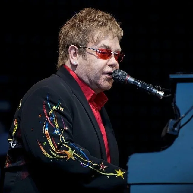 Elton John performing on stage live.
