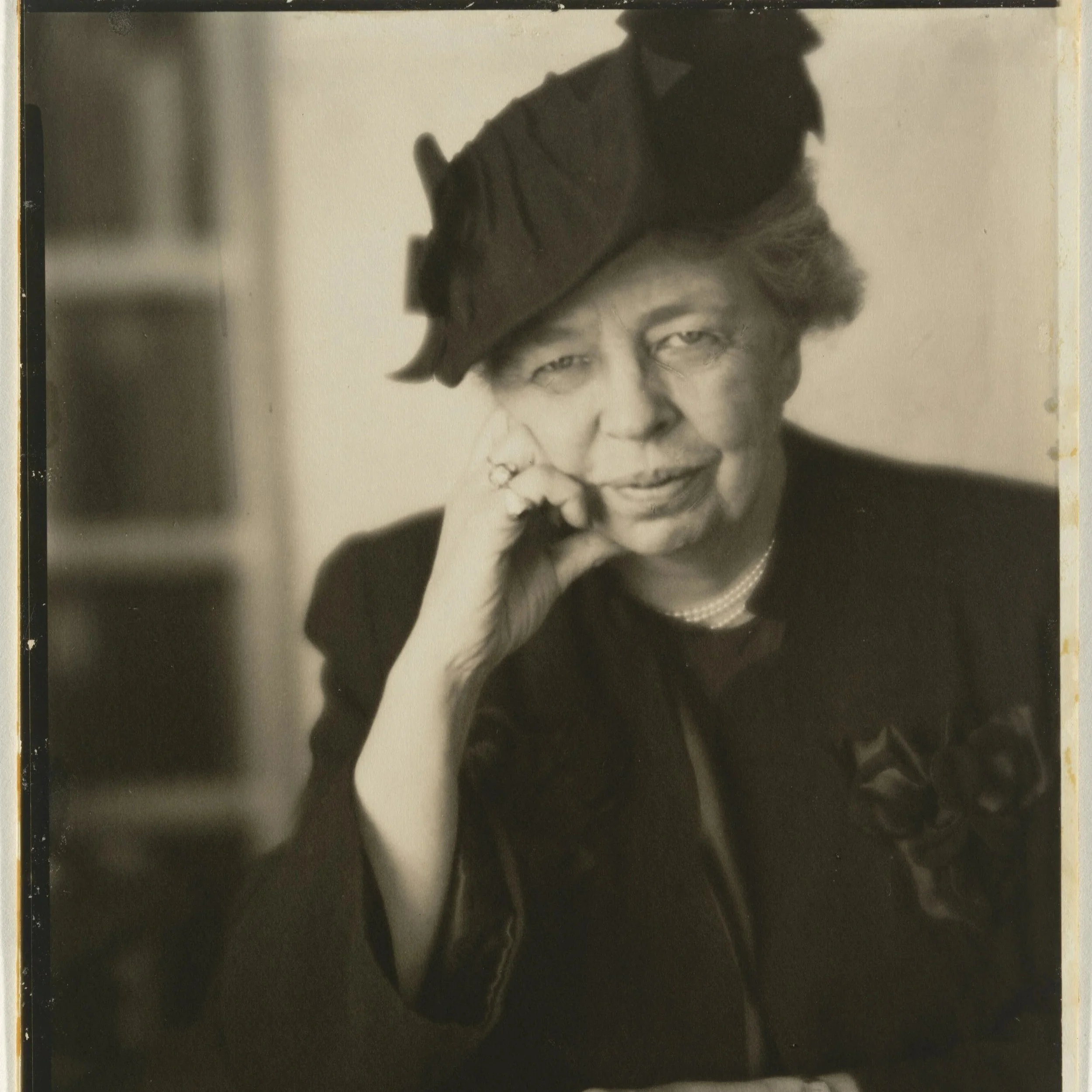 Black and white image of Eleanor Roosevelt wearing a black jacket and hat.