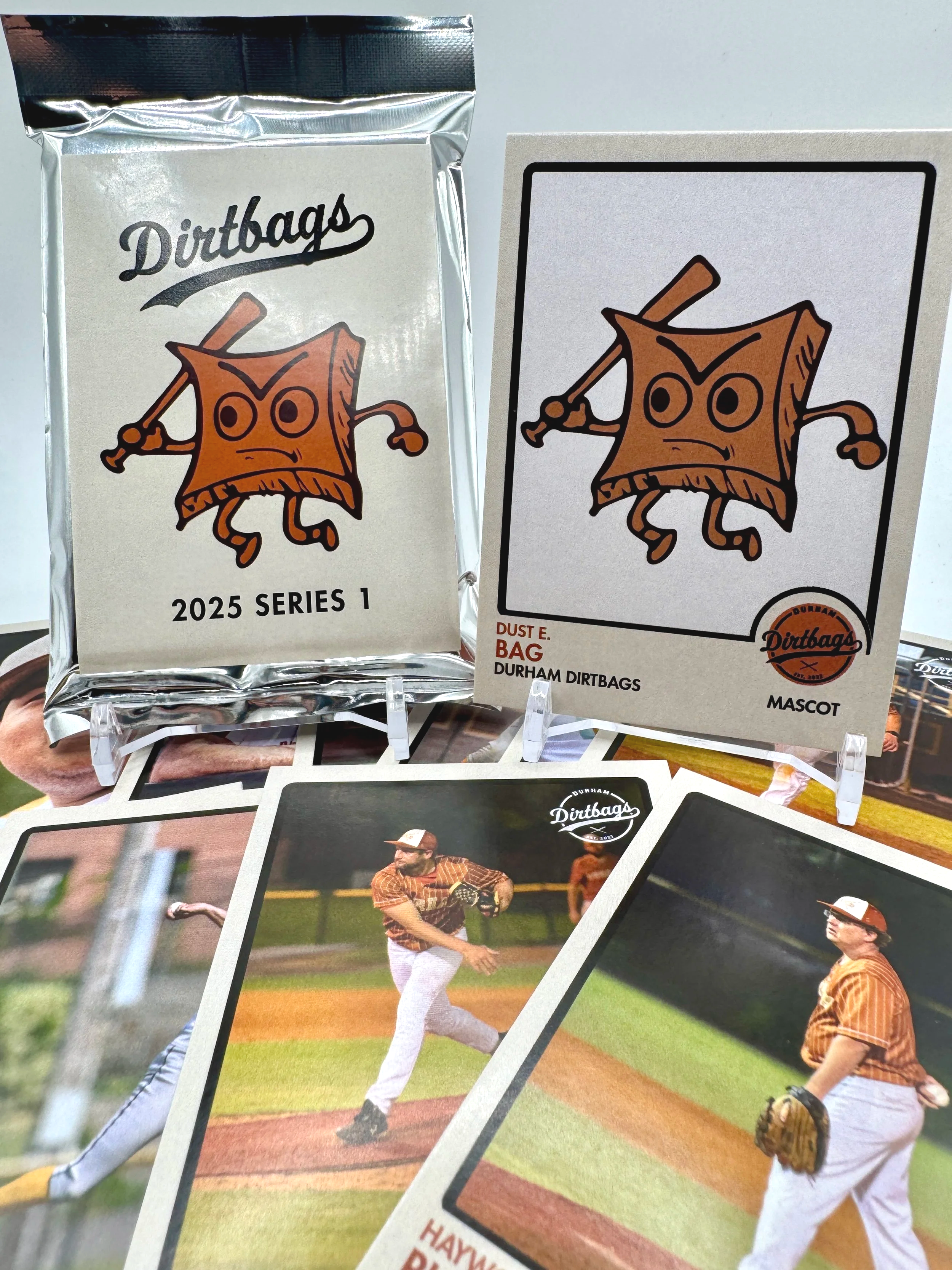 Packaging of Durham Dirtbags baseball cards with a cartoon mascot of an angry dirt bag holding a baseball bat, along with baseball cards showing players in uniform.
