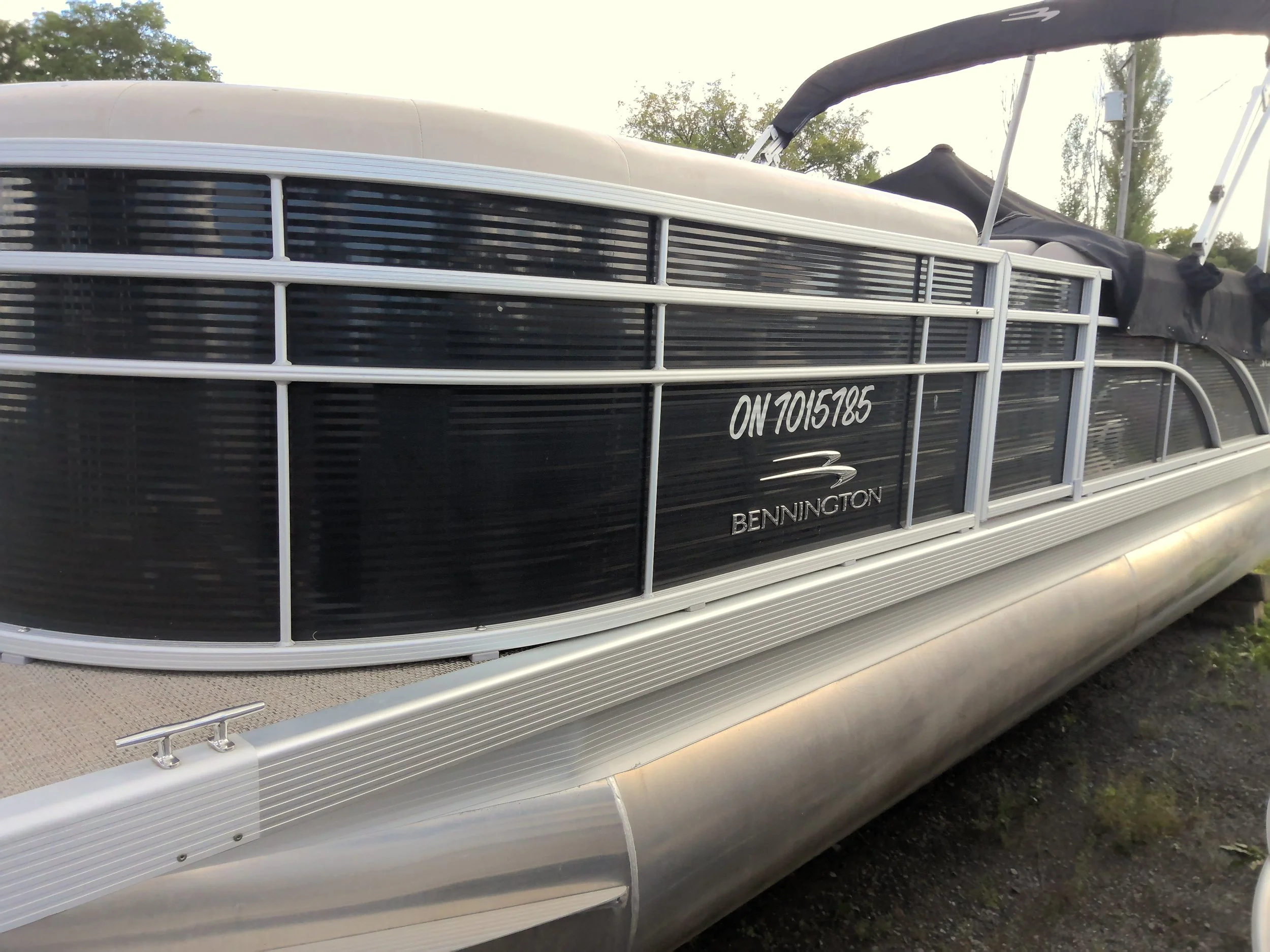 Image of a pontoon boat with a black and white color scheme, featuring the brand name 'Bennington' .