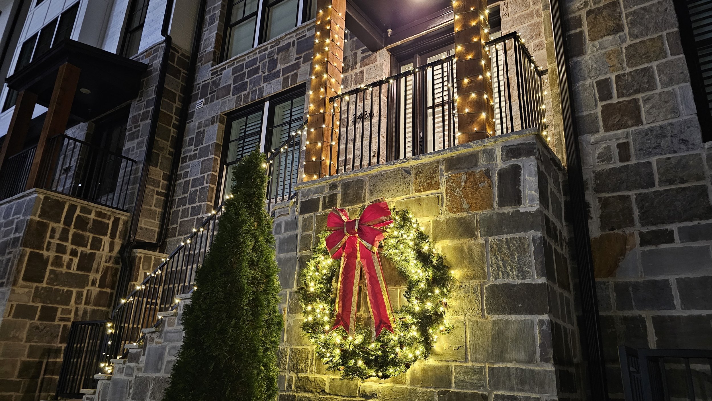 Residential townhome Christmas light installation giant wreath and bow
