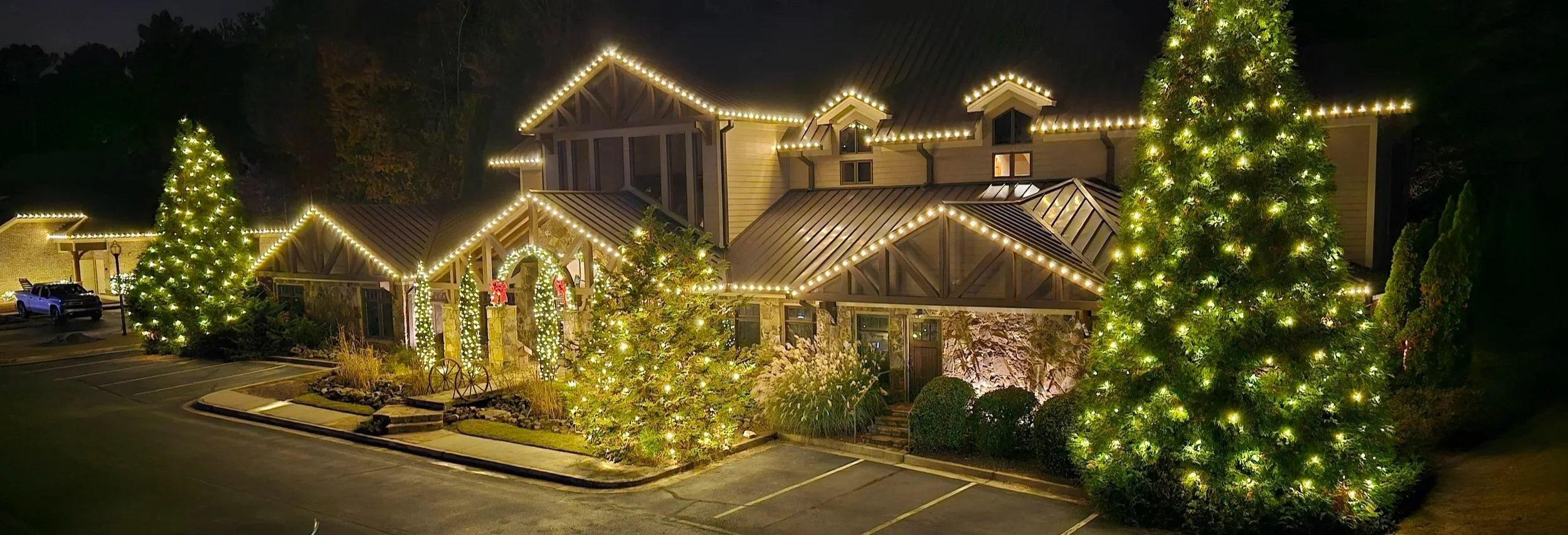 Commercial Christmas light installation Depew Orthodontics Acworth GA Roofline wreaths bows tall evergreens bushes monument lighting