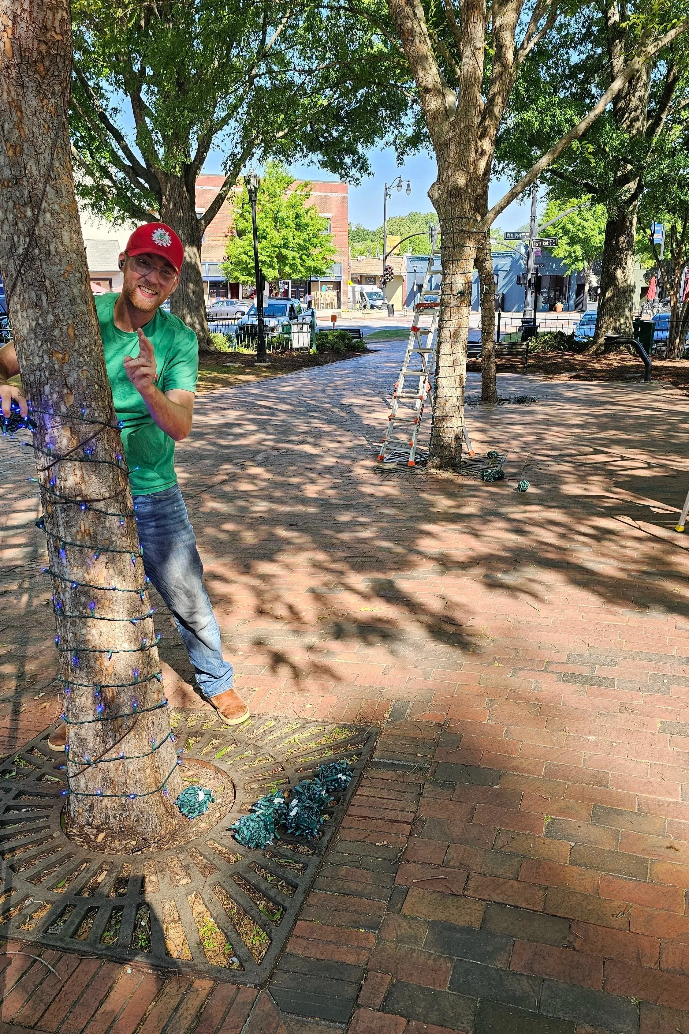 Rich Lighting Co crew worker installing tree lights in Glover Park Marietta Square