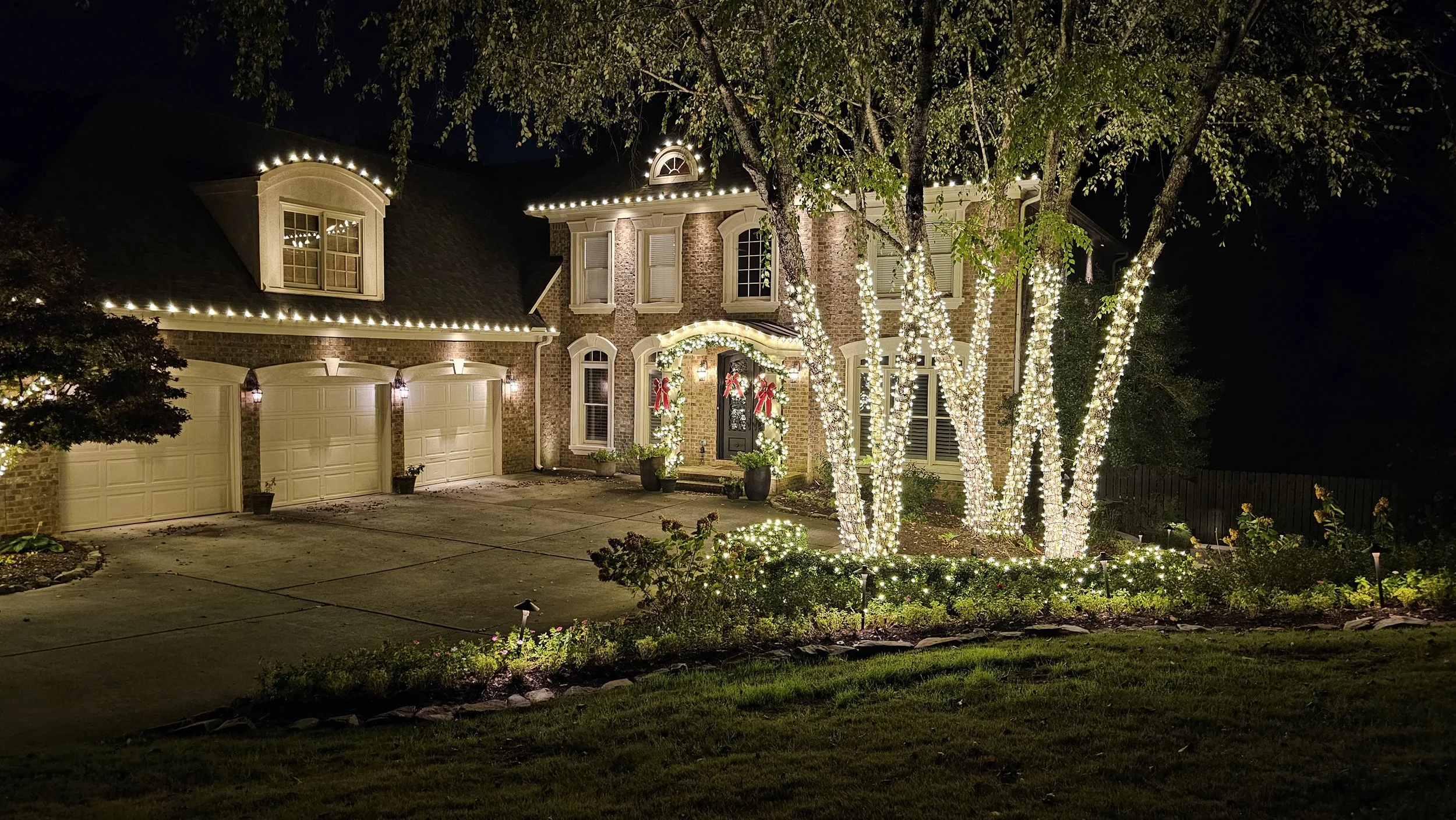High End residential Christmas light installation tree greenery roofline bushes