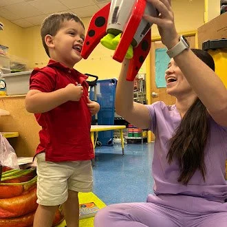 McKenzi with her client in a speech therapy session helping him learn through play