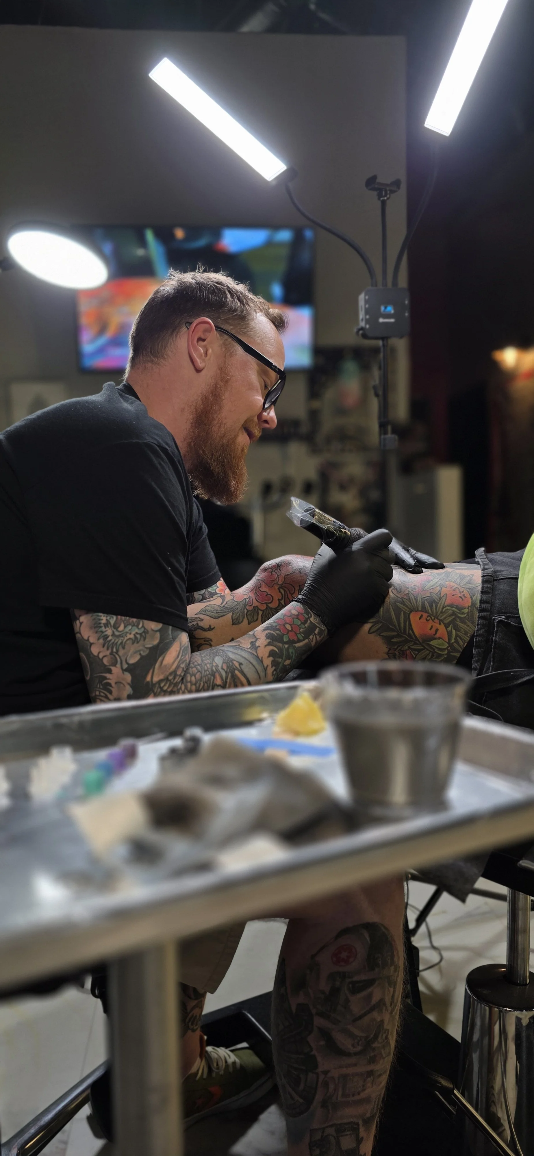 Tattoo Artist tattooing client wearing gloves in sanitary clean Las Vegas tattoo shop