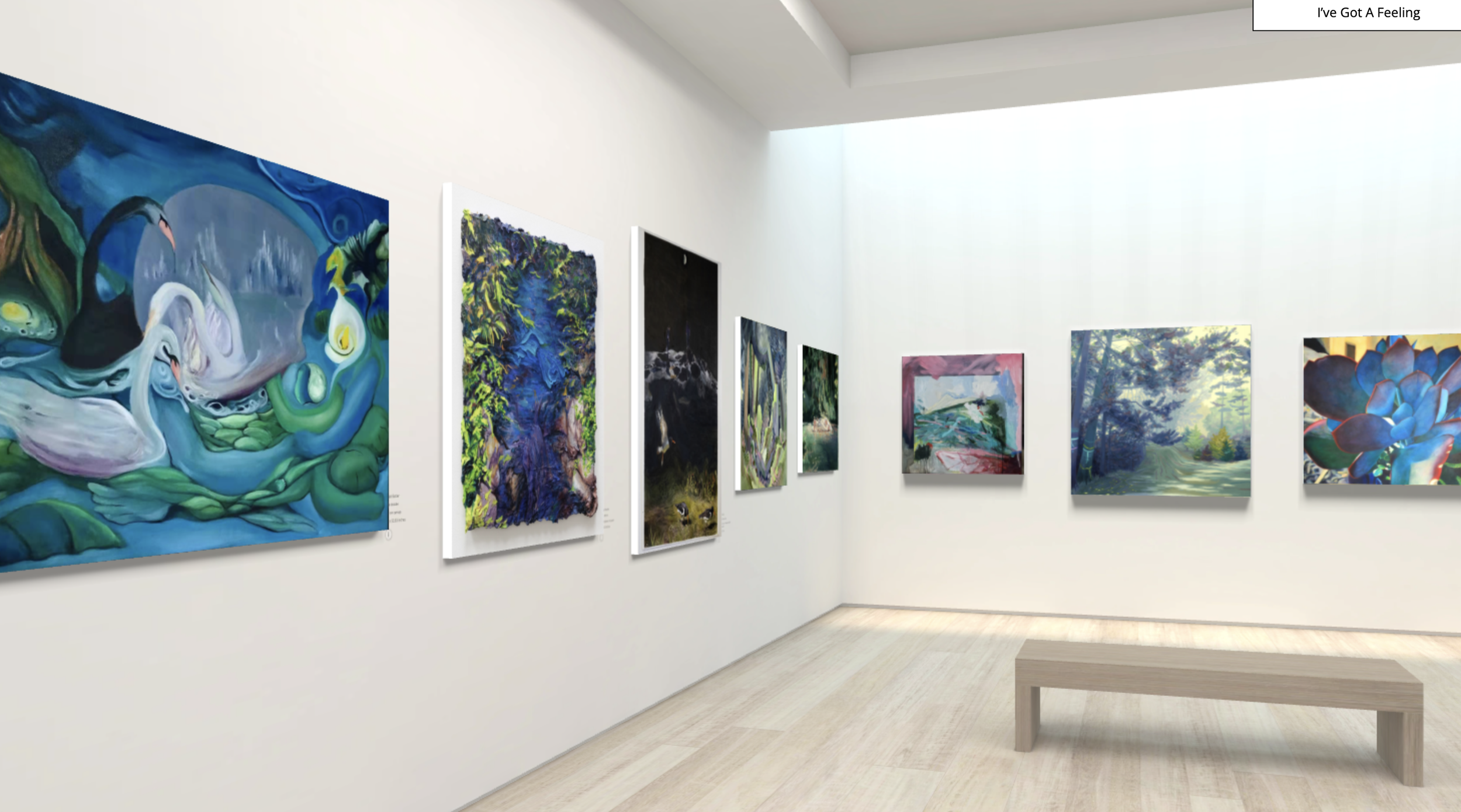 Art gallery with various colorful paintings on white walls, shown in a bright, modern space with light wooden flooring and a bench in the center.