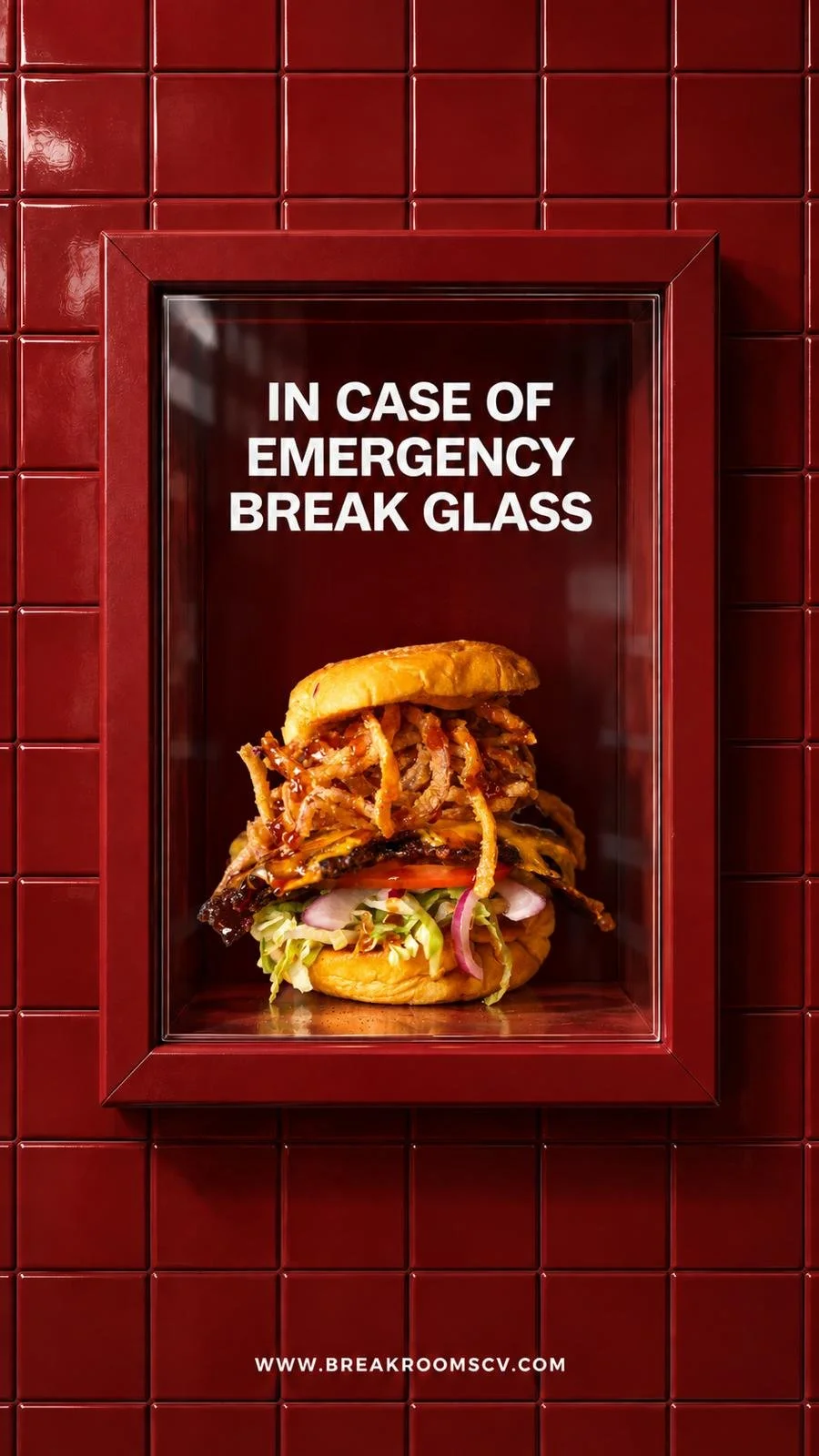 A red emergency break glass box with a sign that reads 'In case of emergency break glass' and a large burger sandwich inside.