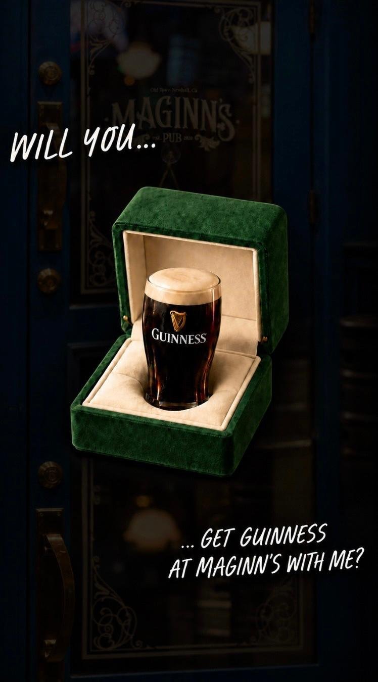 A pint of Guinness beer in a green velvet box with white interior, with text saying ‘Will you... get Guinness at Maginn’s with me?’