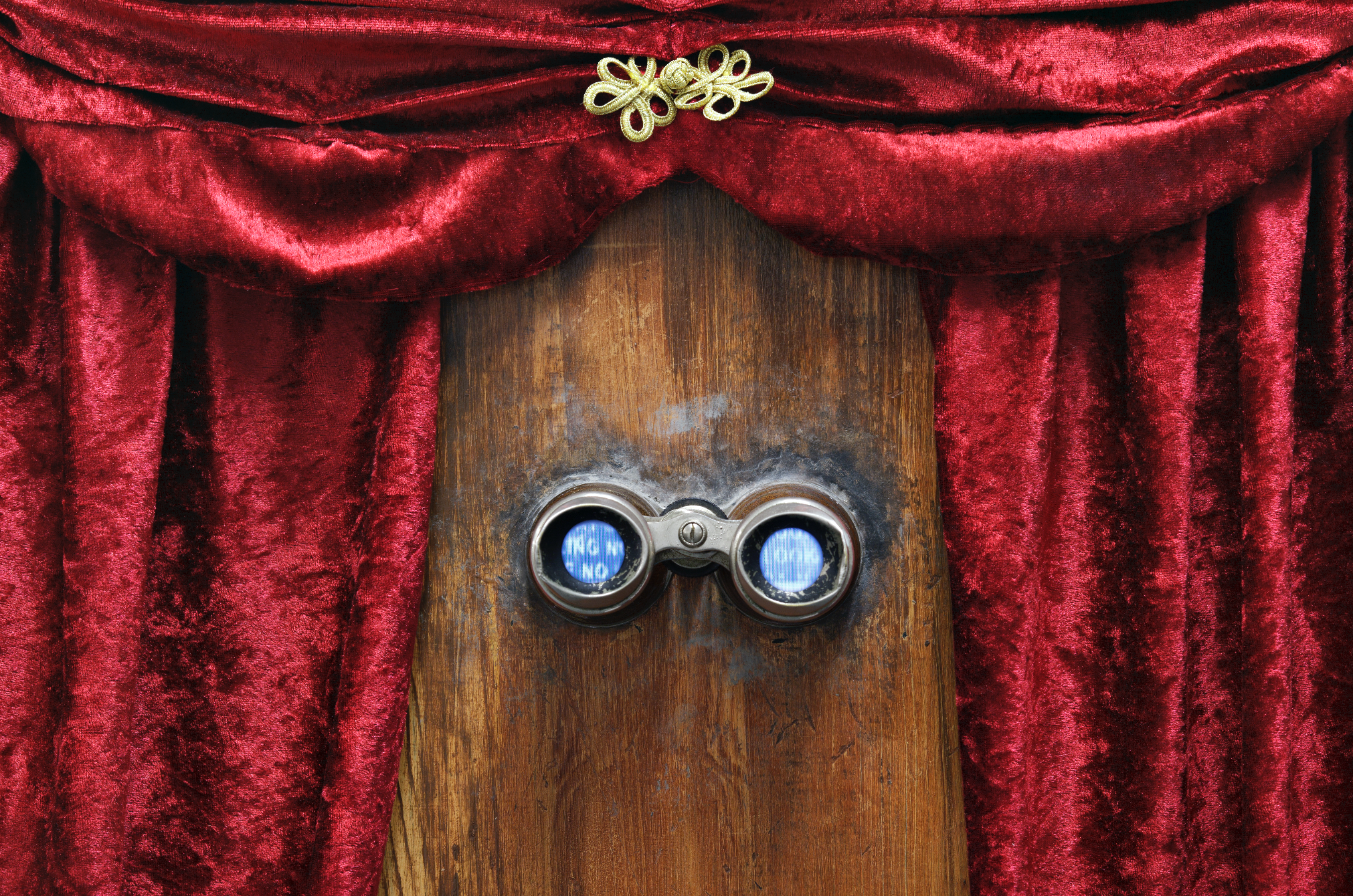 Antique stereoscope with red velvet drapes and wooden panel