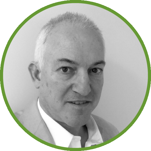Dr Zwi wearing a suit and tie. The image is circular with a green border.