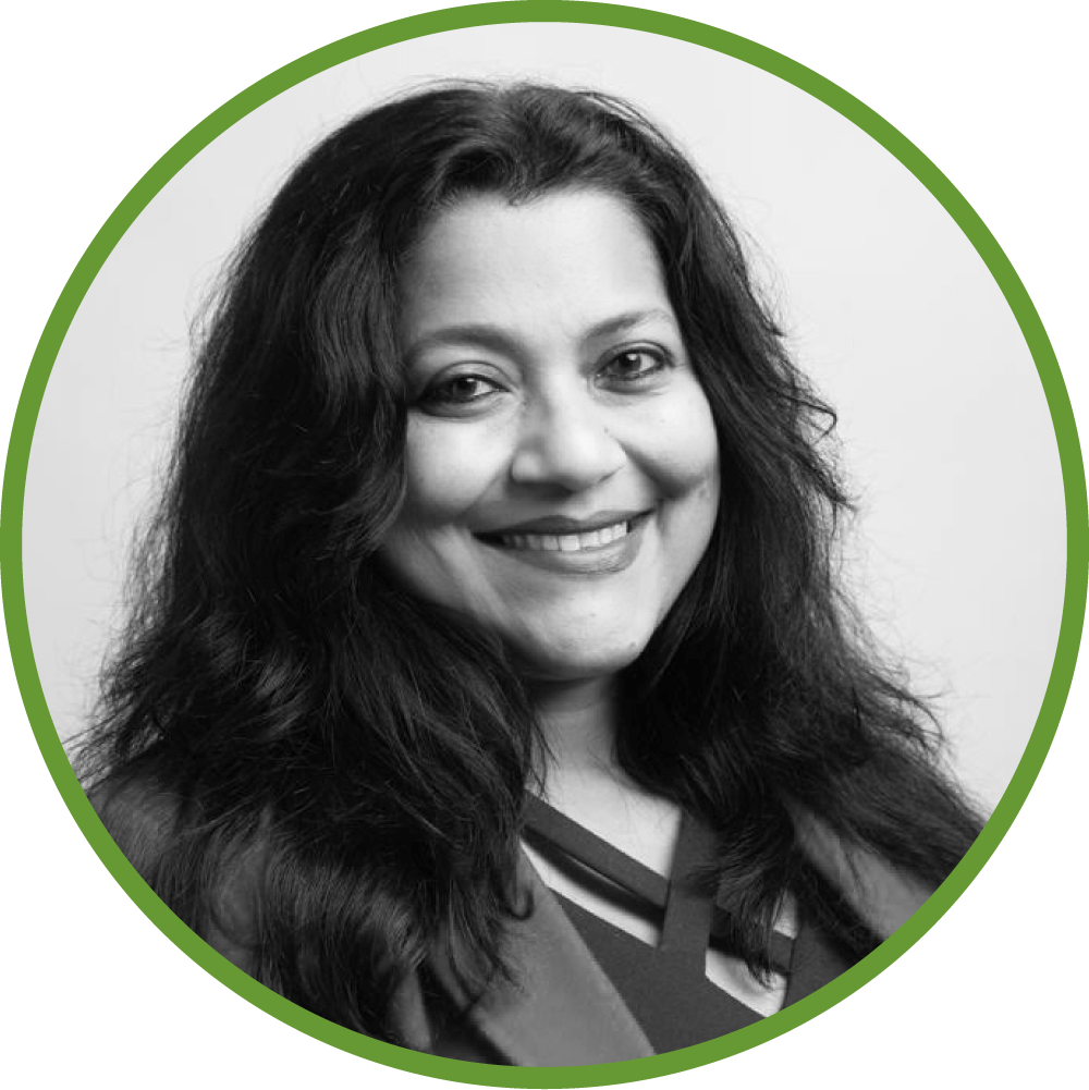 Dr Sudipta Sen smiling with long, dark hair, framed with green circle.