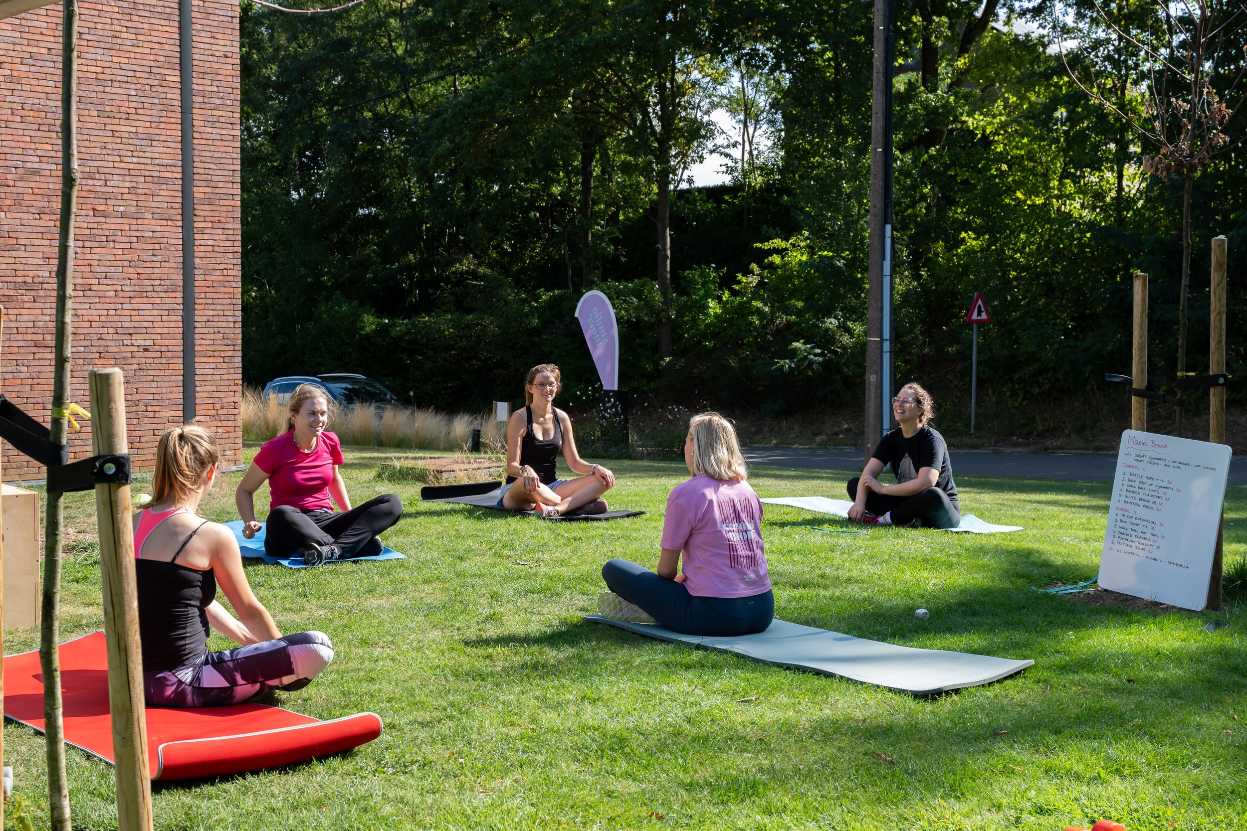Buitenlocatie van Studio Moer met verschillende mama's die buiten napraten na een groepsles