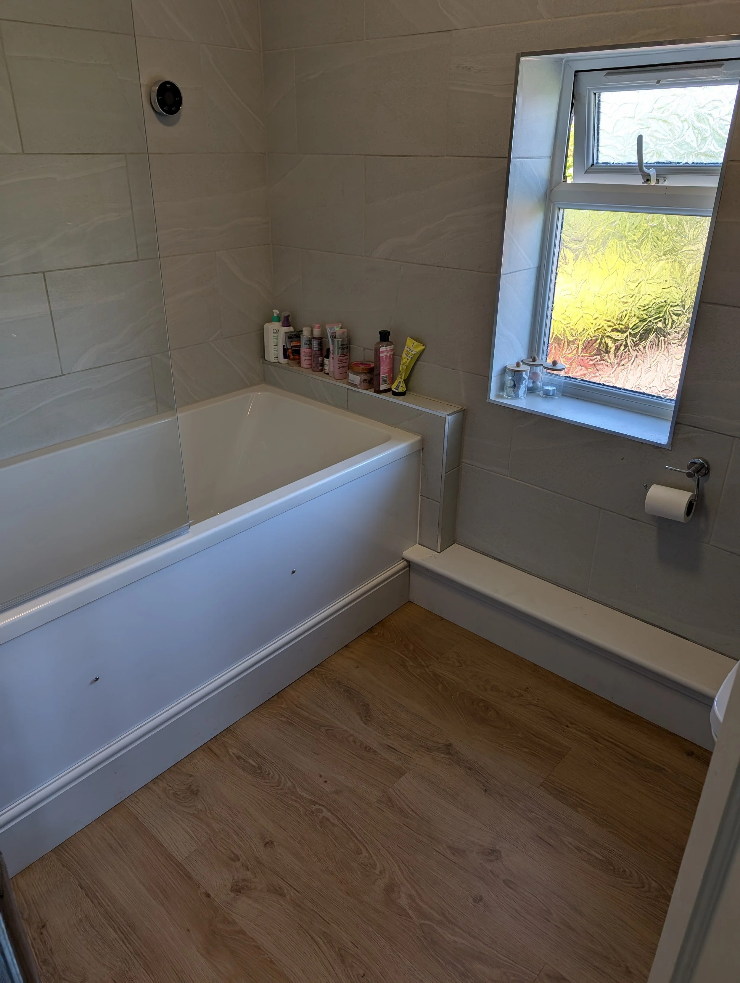 LVT click flooring for the bathroom with new skirting, boxing and bath panel all to match