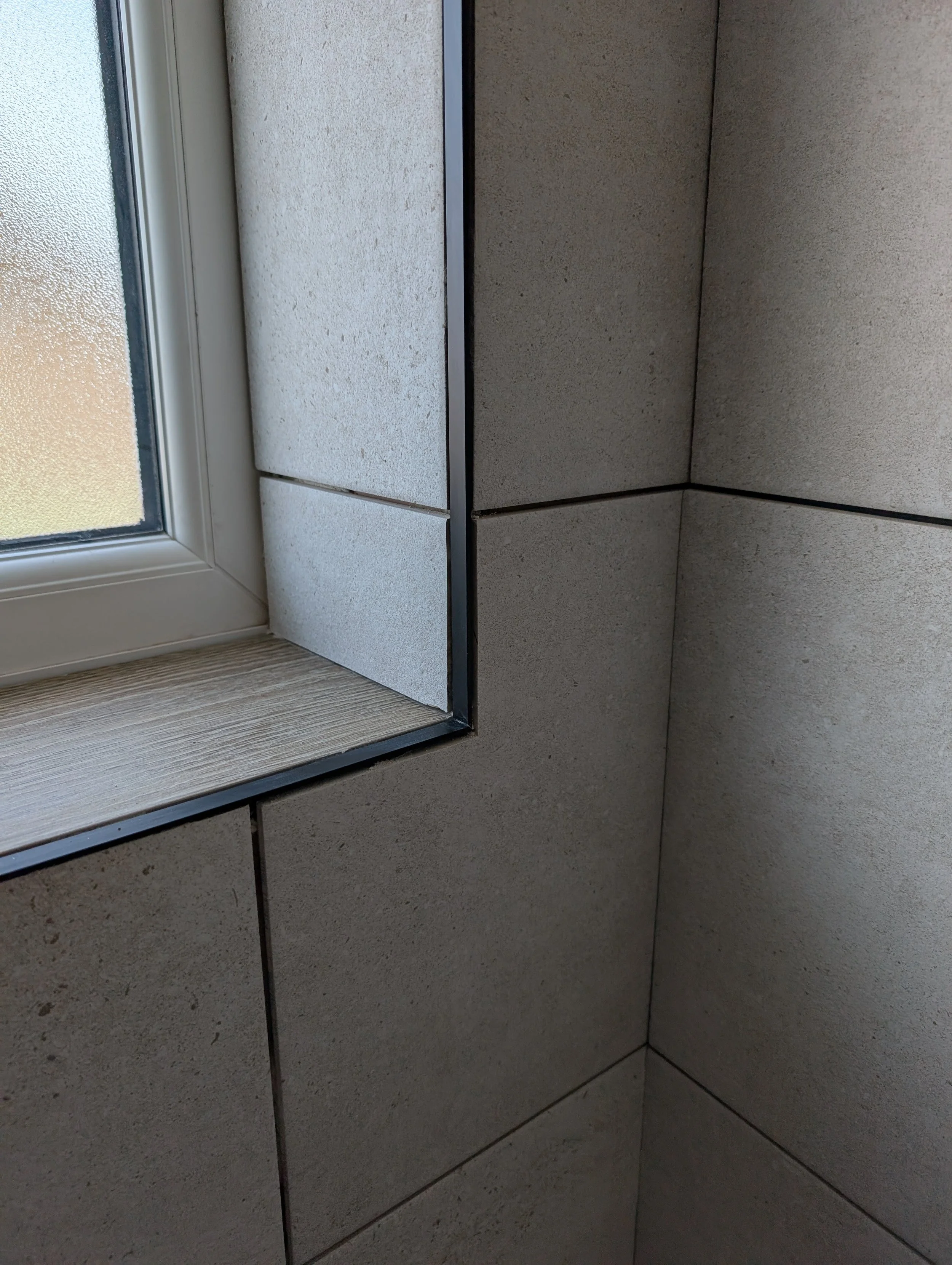 Tidy work around the windows, we'll match the trim to the grout colour for consistency