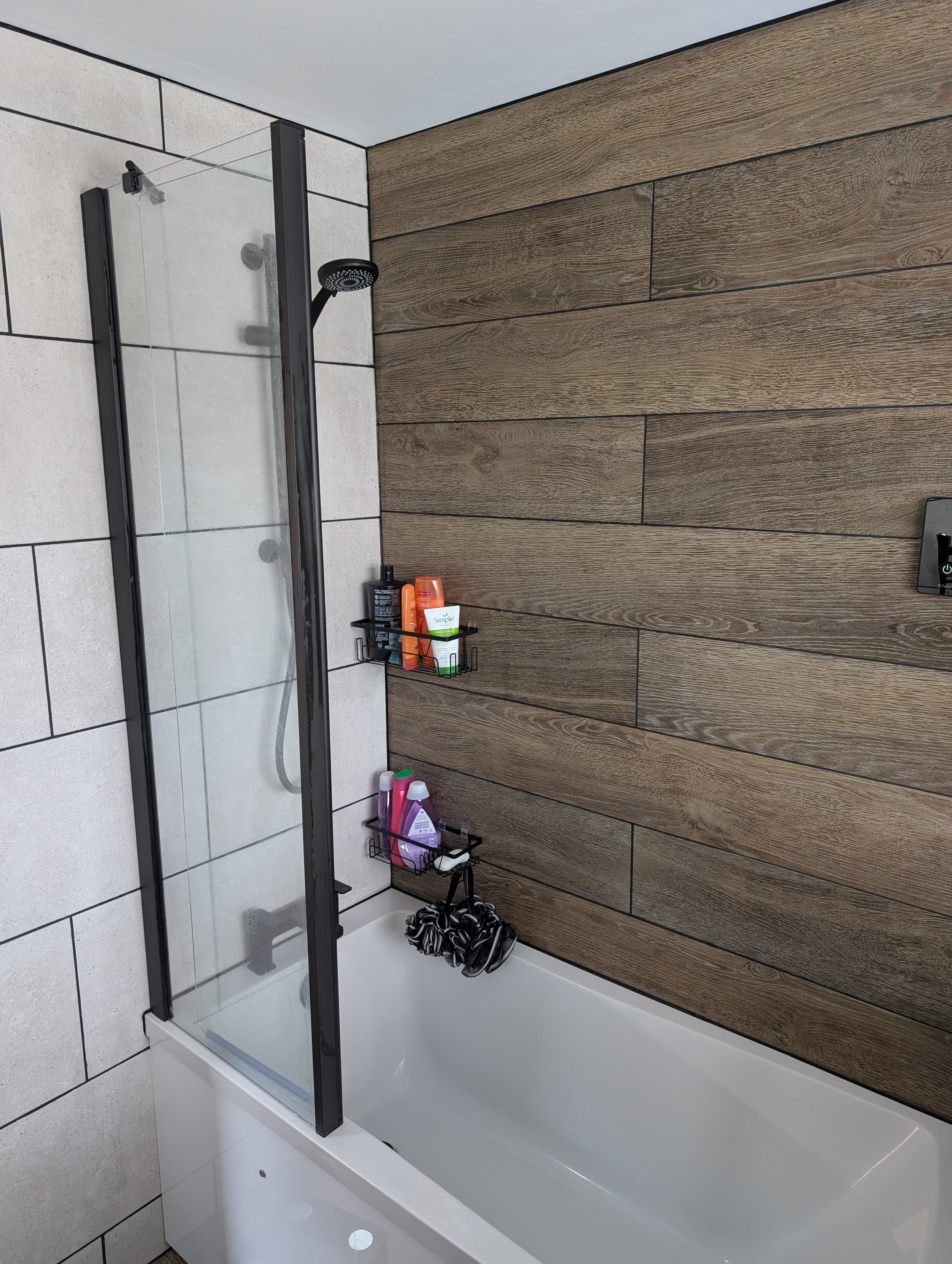 A striking plant tile to the wall which flows through to the floor, digital shower and matching bath screen - sourced specifically to allow the client easy access to the taps to bathe a younger child