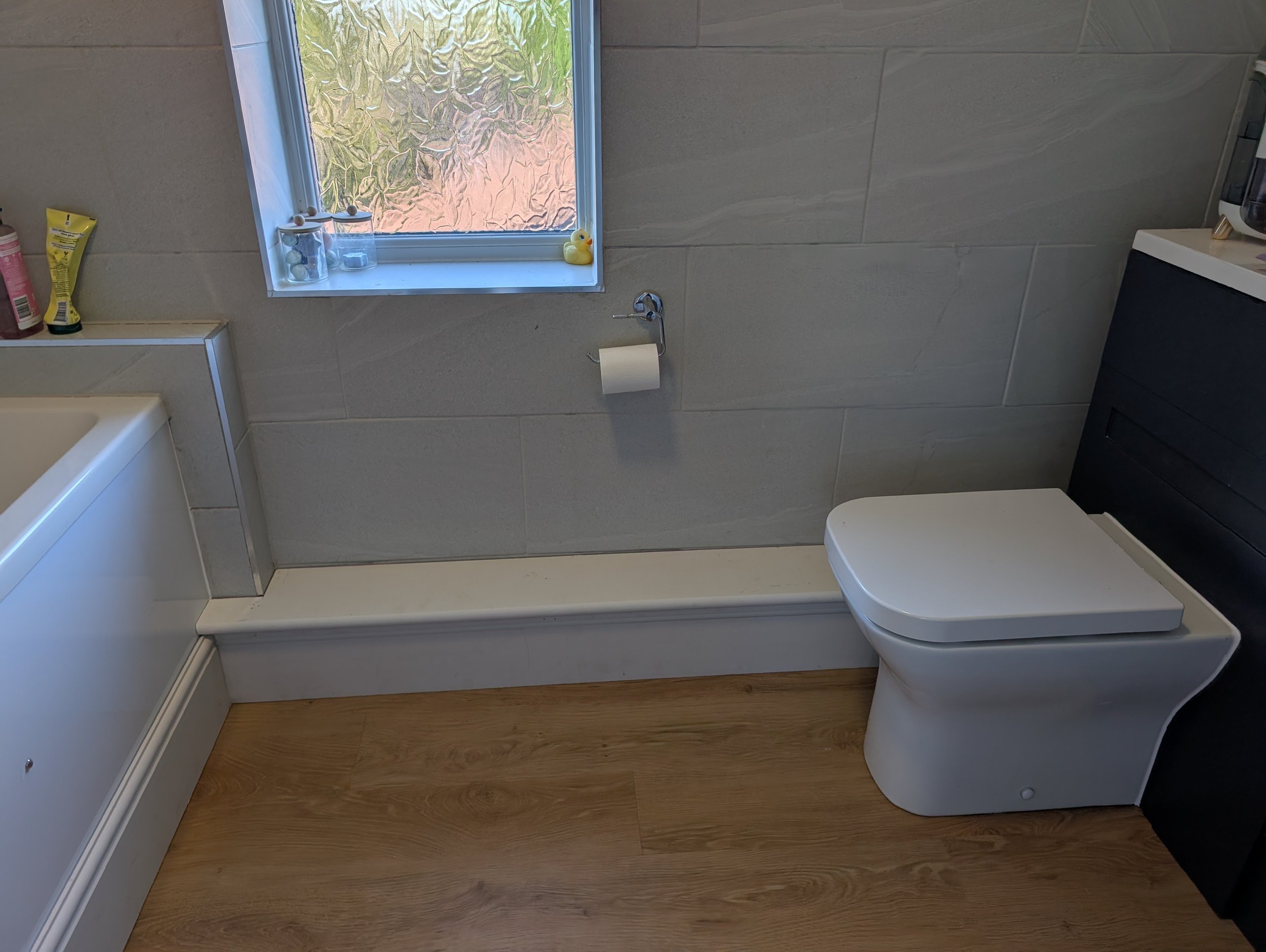 LVT click flooring for the bathroom with new skirting, boxing and bath panel all to match