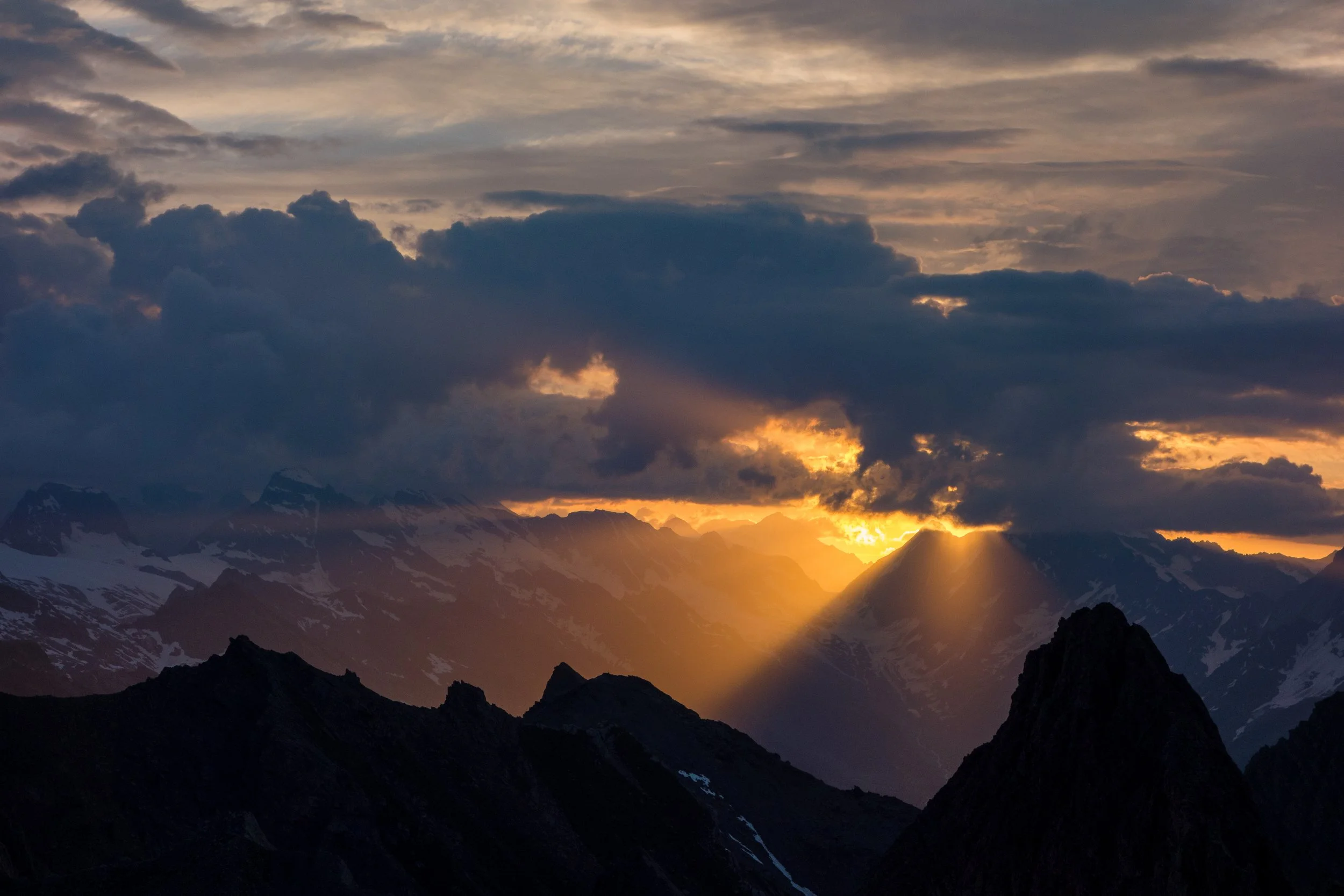 A photo of the sun piercing the clouds at sunrise