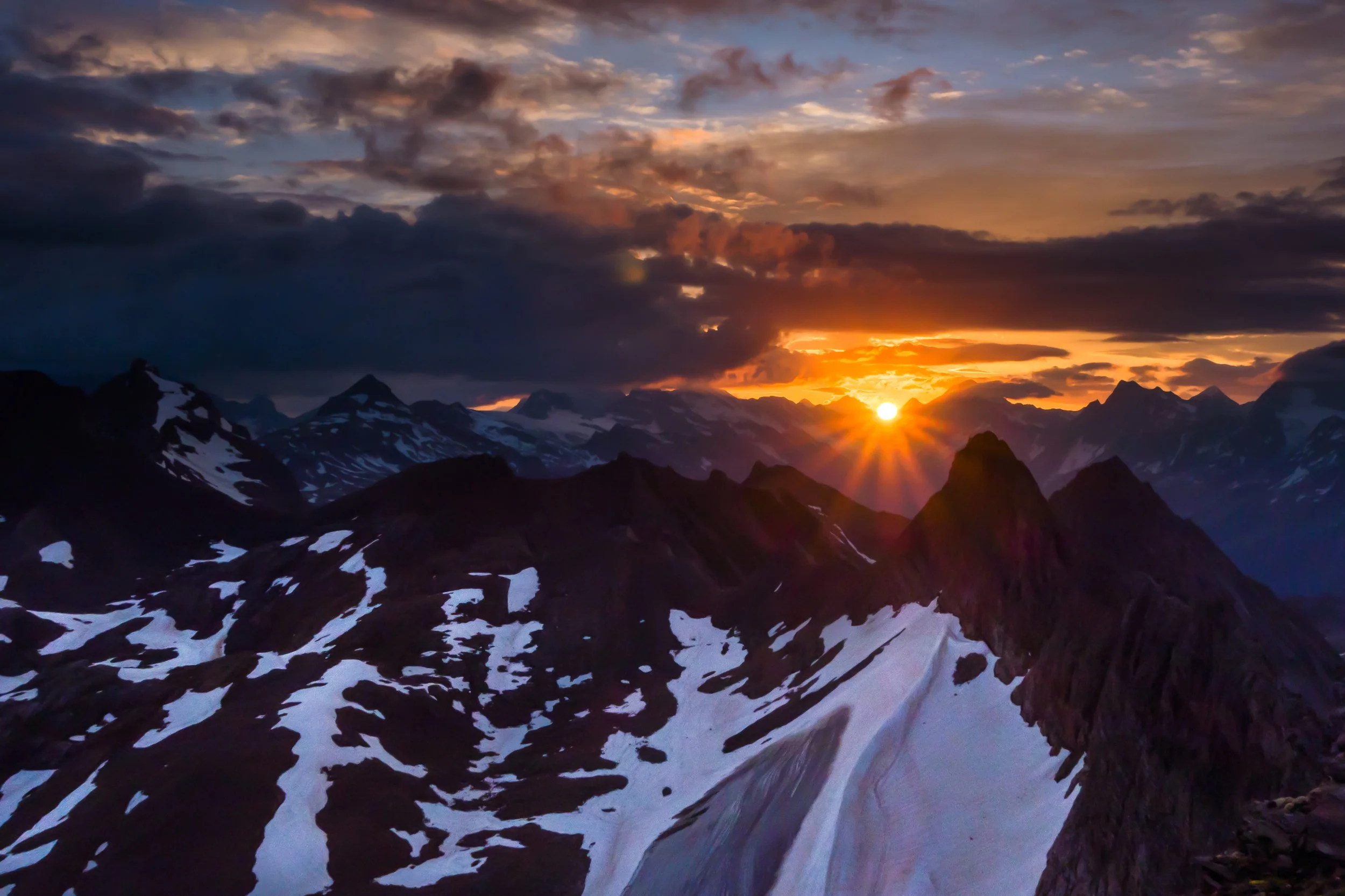 The sun's rays visible just as it rises above the Swiss Alps