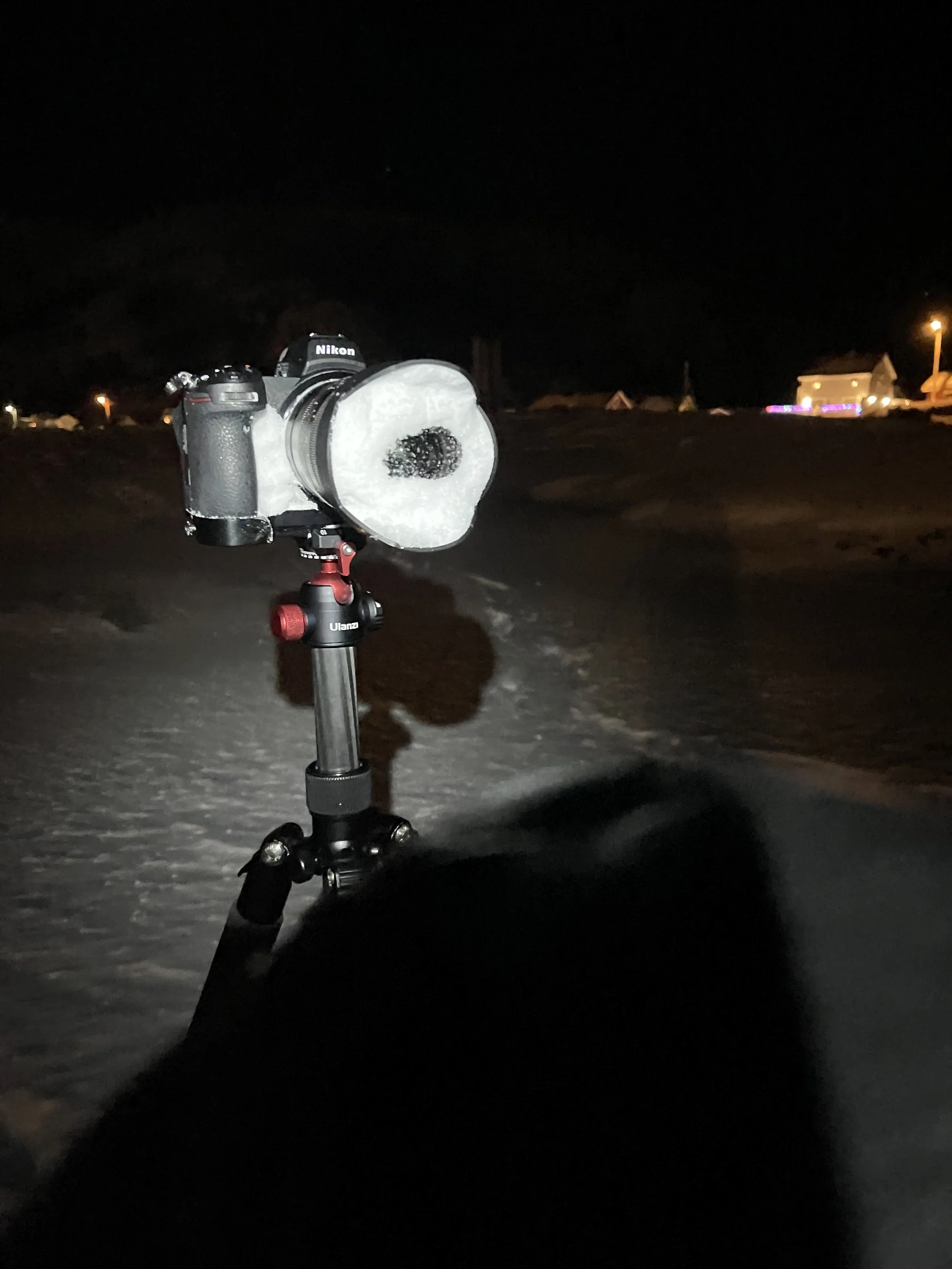 Nikon Z7ii camera on tripod with lens covered in snow