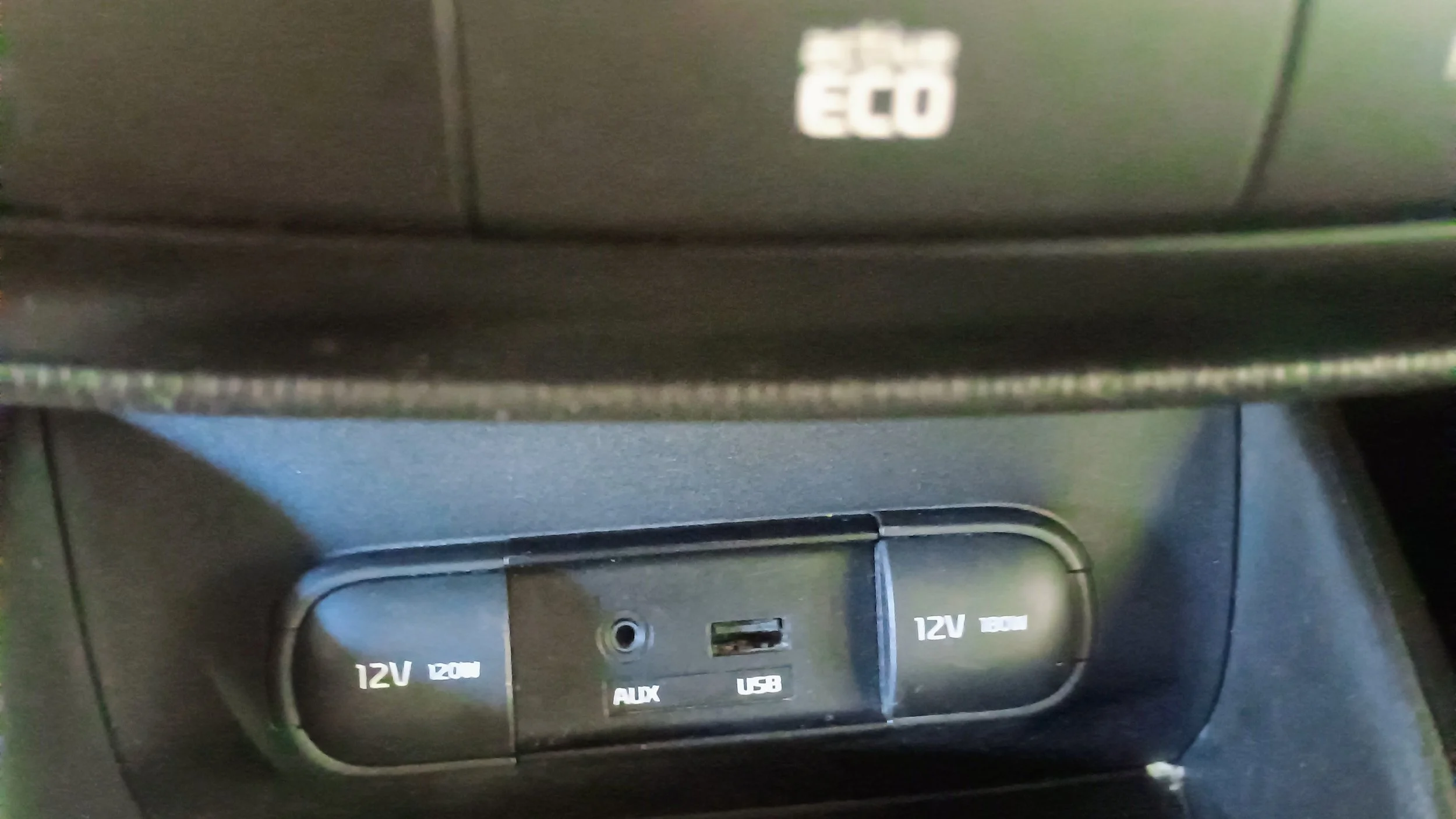 Car interior power outlet panel with two 12V sockets, an AUX port, and a USB port.