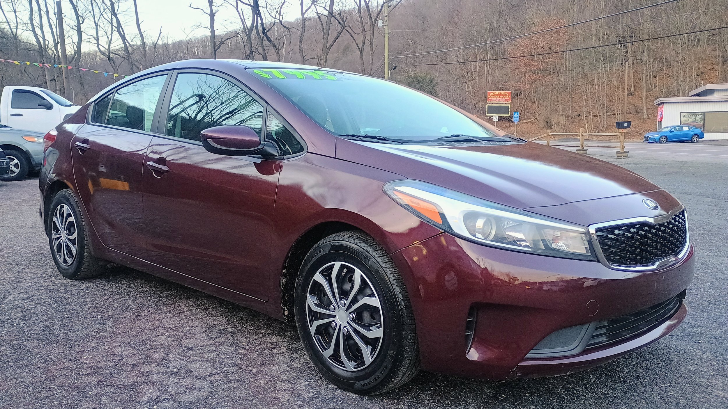 A maroon Volkswagen sedan parked in a car dealership lot.
