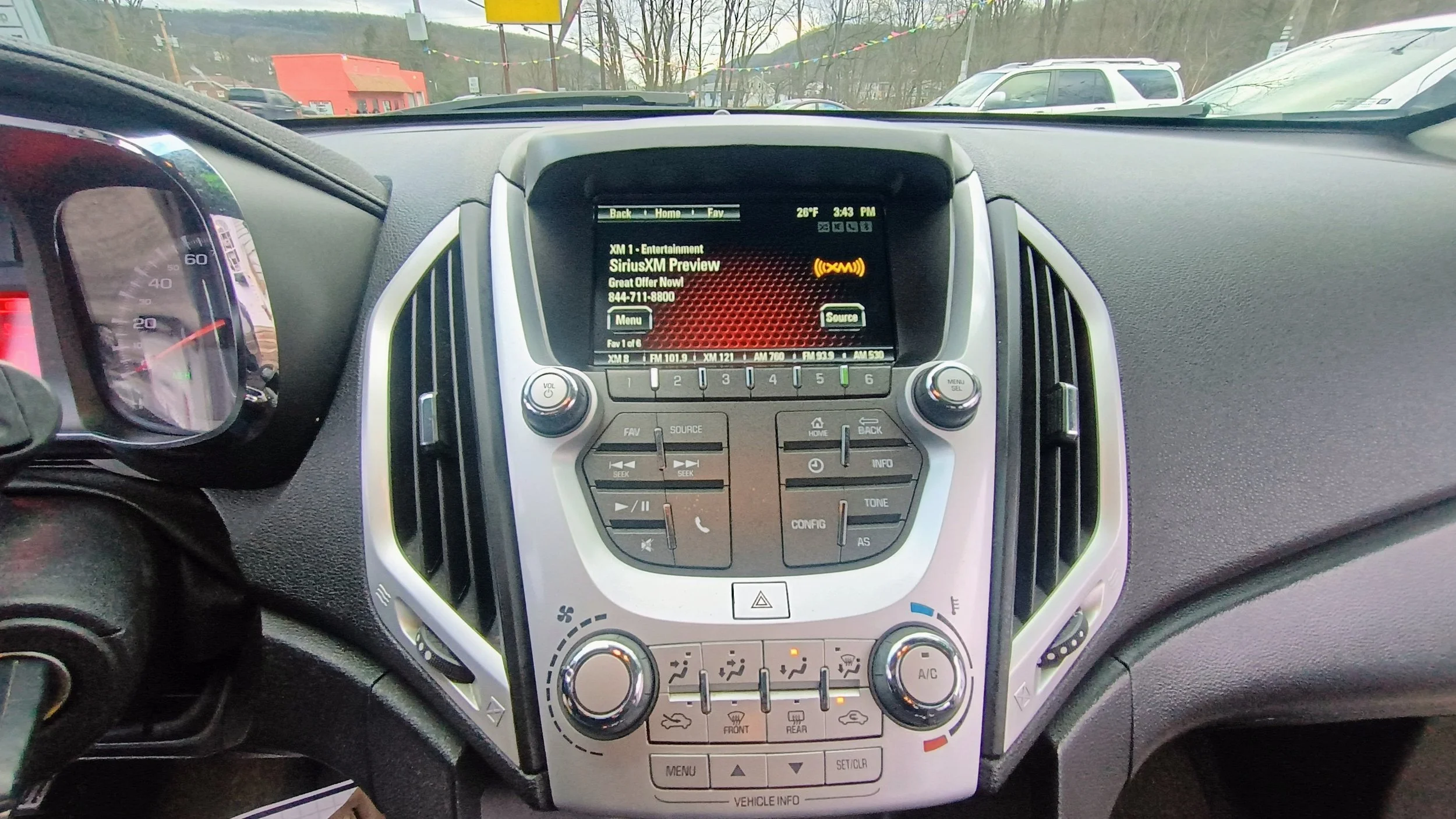 The interior dashboard of a vehicle showing the center console with an infotainment screen tuned to SiriusXM Preview, vehicle climate controls, and various buttons and knobs.