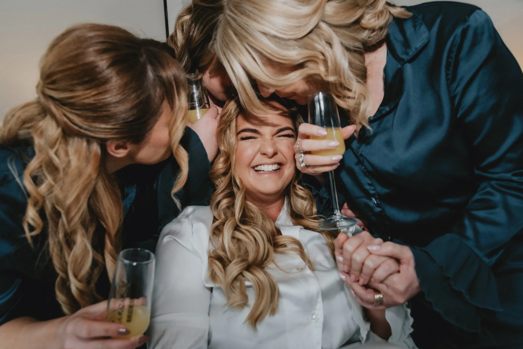 Group of women celebrating with smiles, glasses of champagne, and close friends.