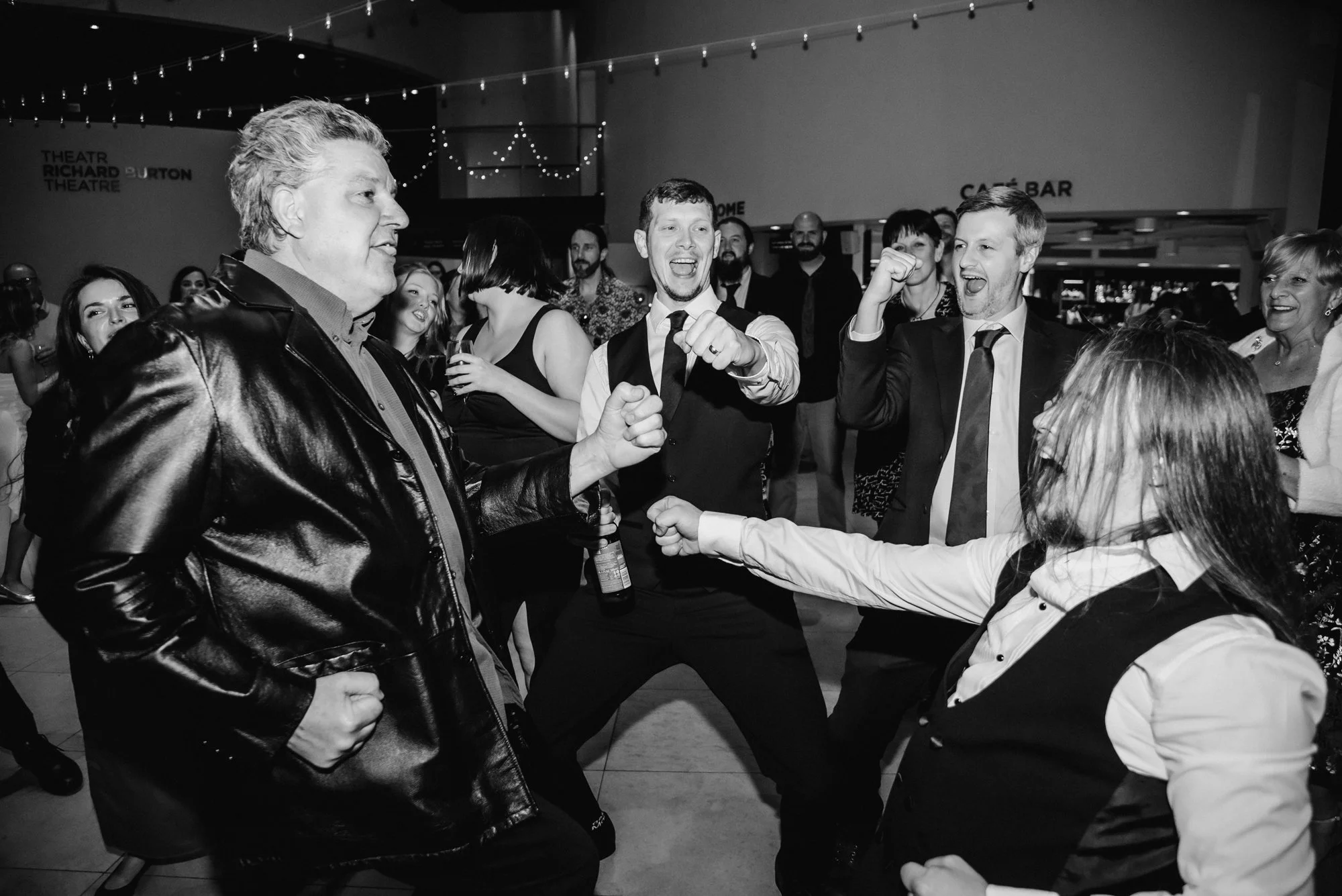 People dancing and having fun at a party or celebration in a large indoor venue.