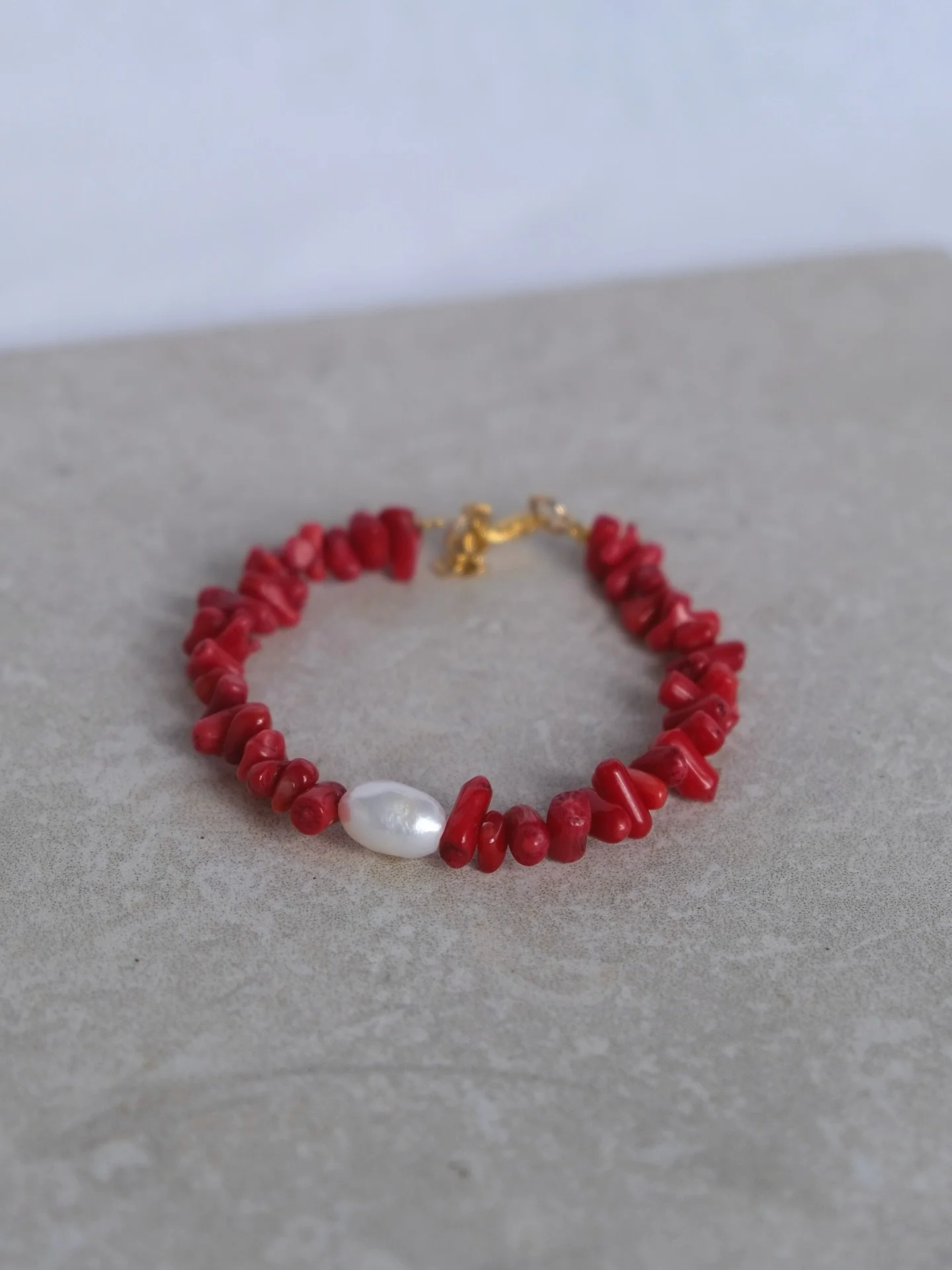Bracelet A&iuml;noa 

Ce bracelet associe des perles imitation corail rouge &agrave; une perle d&rsquo;eau douce naturelle pour un rendu d&eacute;licat et &eacute;l&eacute;gant ✨