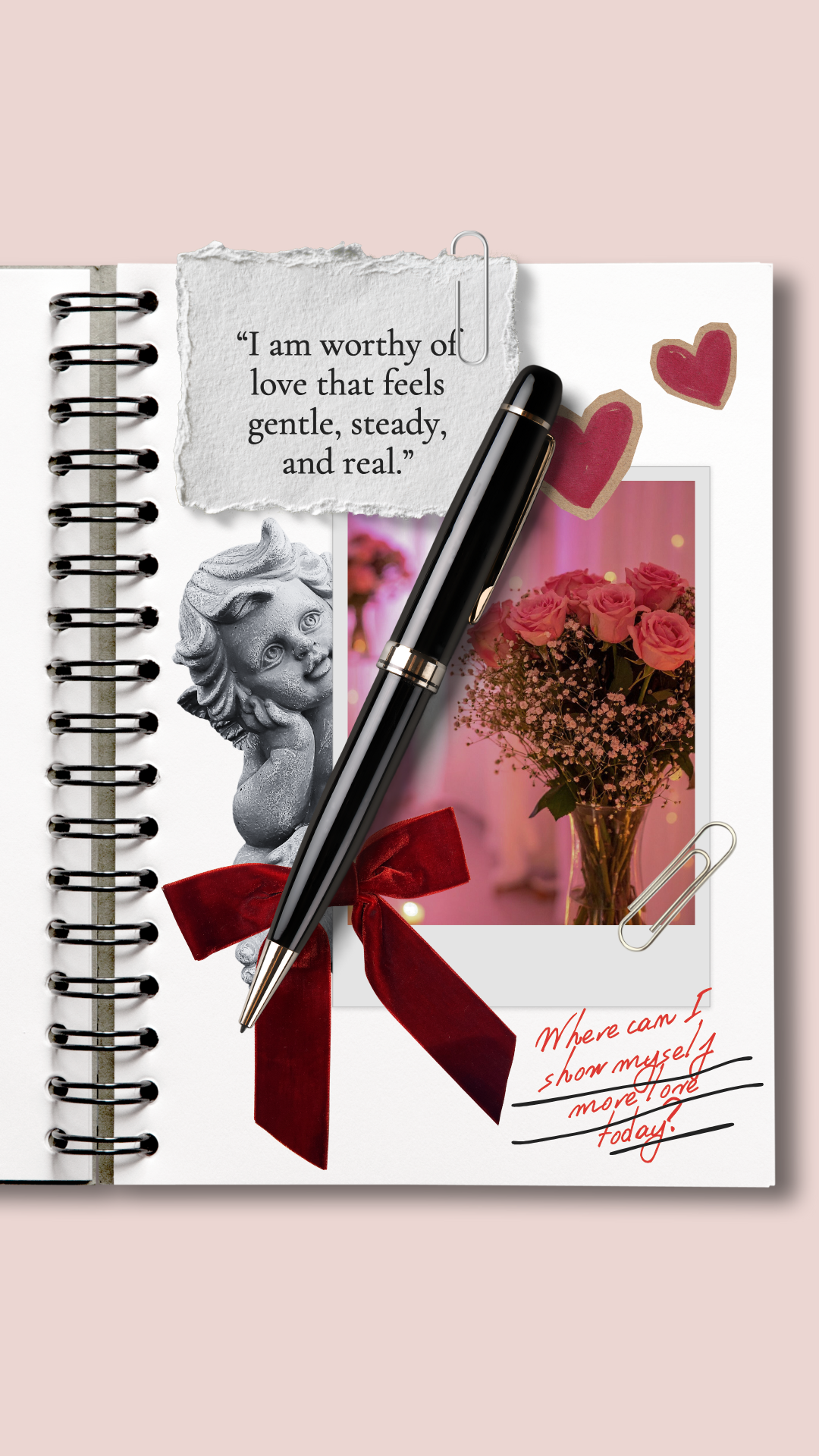 A spiral notebook page with a torn note reading "I am worthy of love that feels gentle, steady, and real." A black pen lies across the page, with two red heart drawings and a photograph of pink roses in a vase. There is a small gray angel figurine and a red ribbon tied into a bow. Handwritten text in red and black says, "Where can I show myself more love today!"
