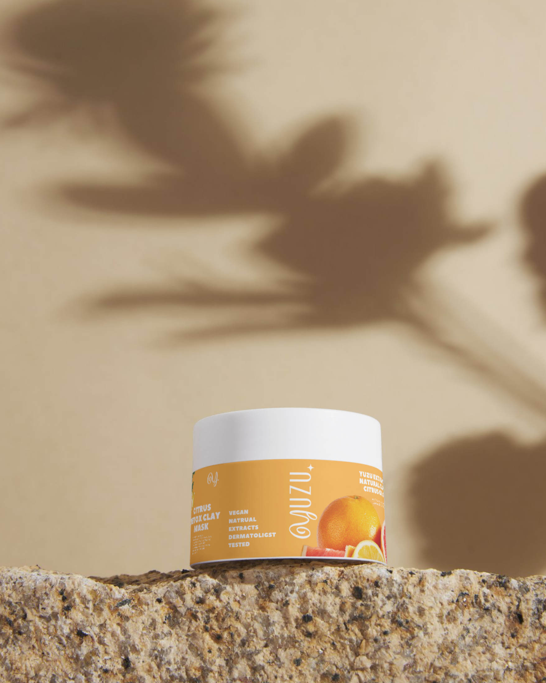 Citrus detox clay mask skincare product photographed on a textured stone surface.