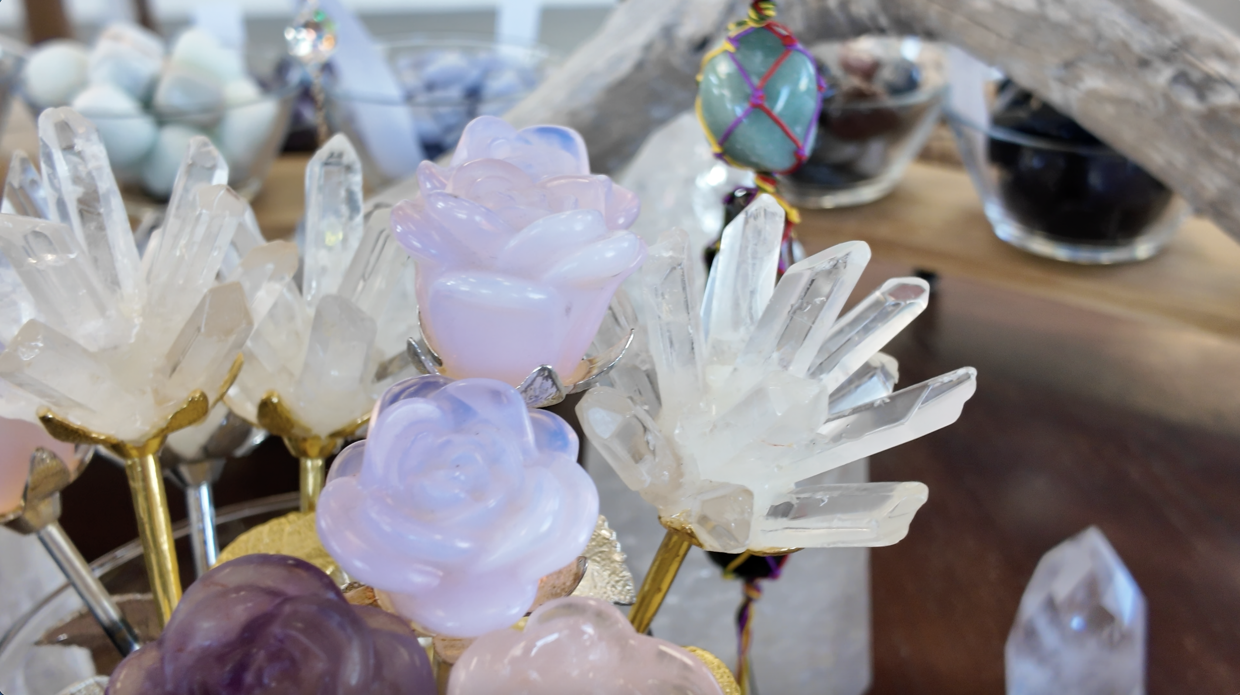 Decorative glass flowers and crystals on a display table.
