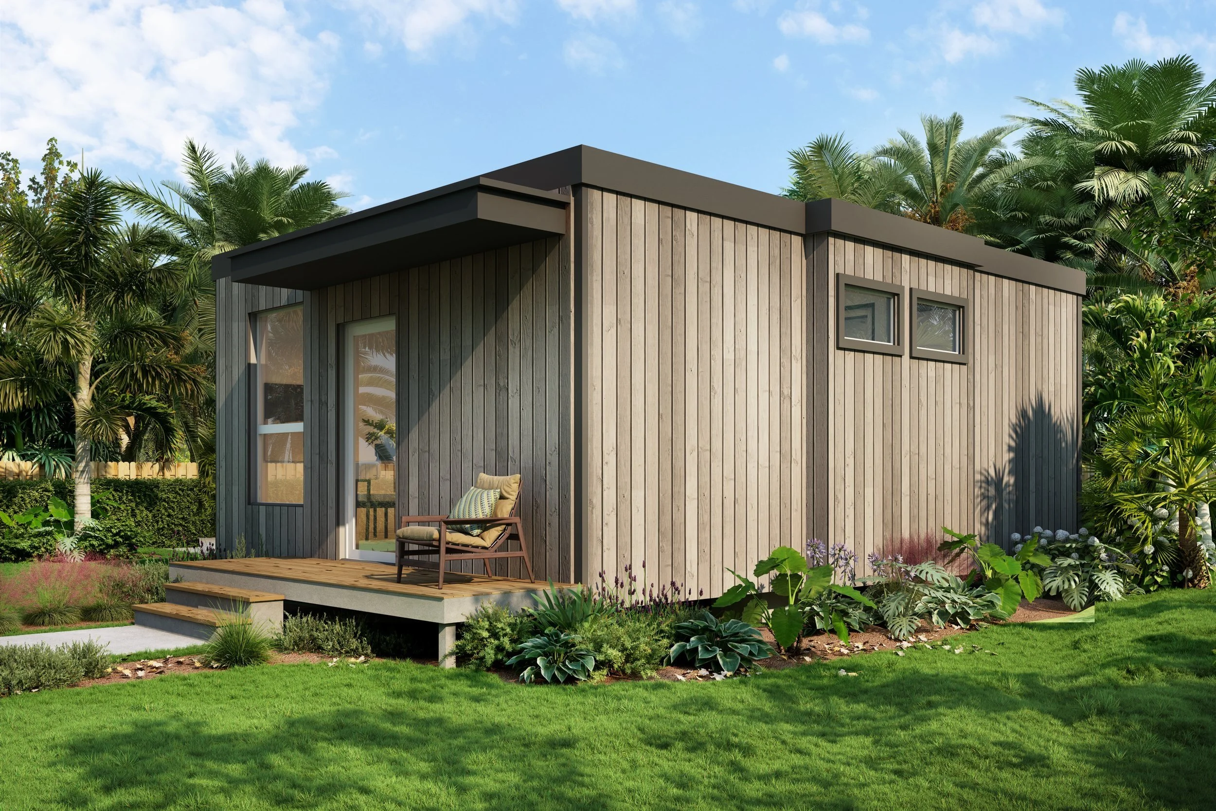 A small modern wooden house with a porch, surrounded by lush greenery and tropical plants, under a blue sky.