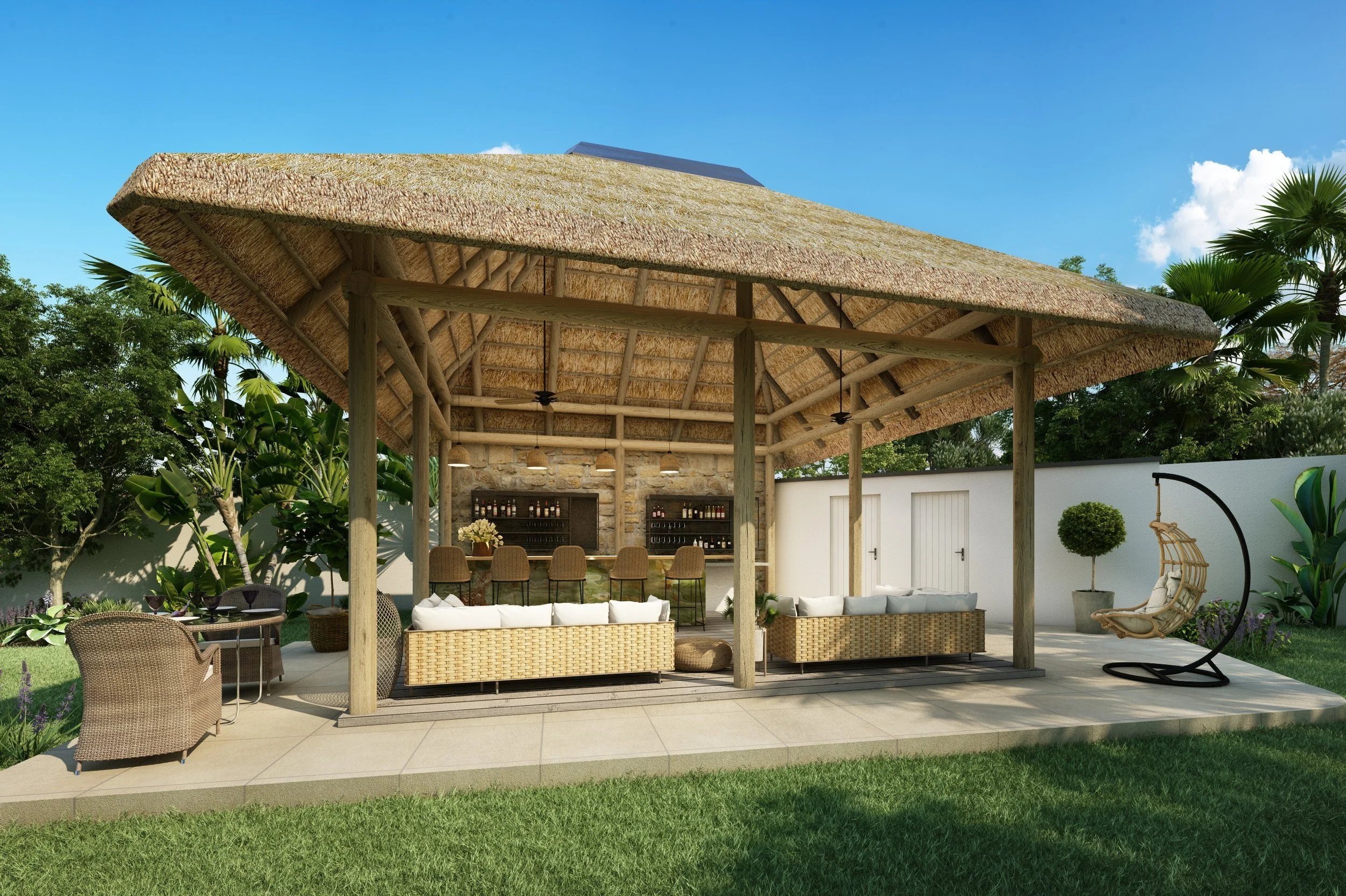Outdoor lounge area with a thatched roof, wicker sofas with white cushions, bar stools at a bar with bottles, a hanging egg chair, a patio table and chairs, surrounded by greenery and a white wall.