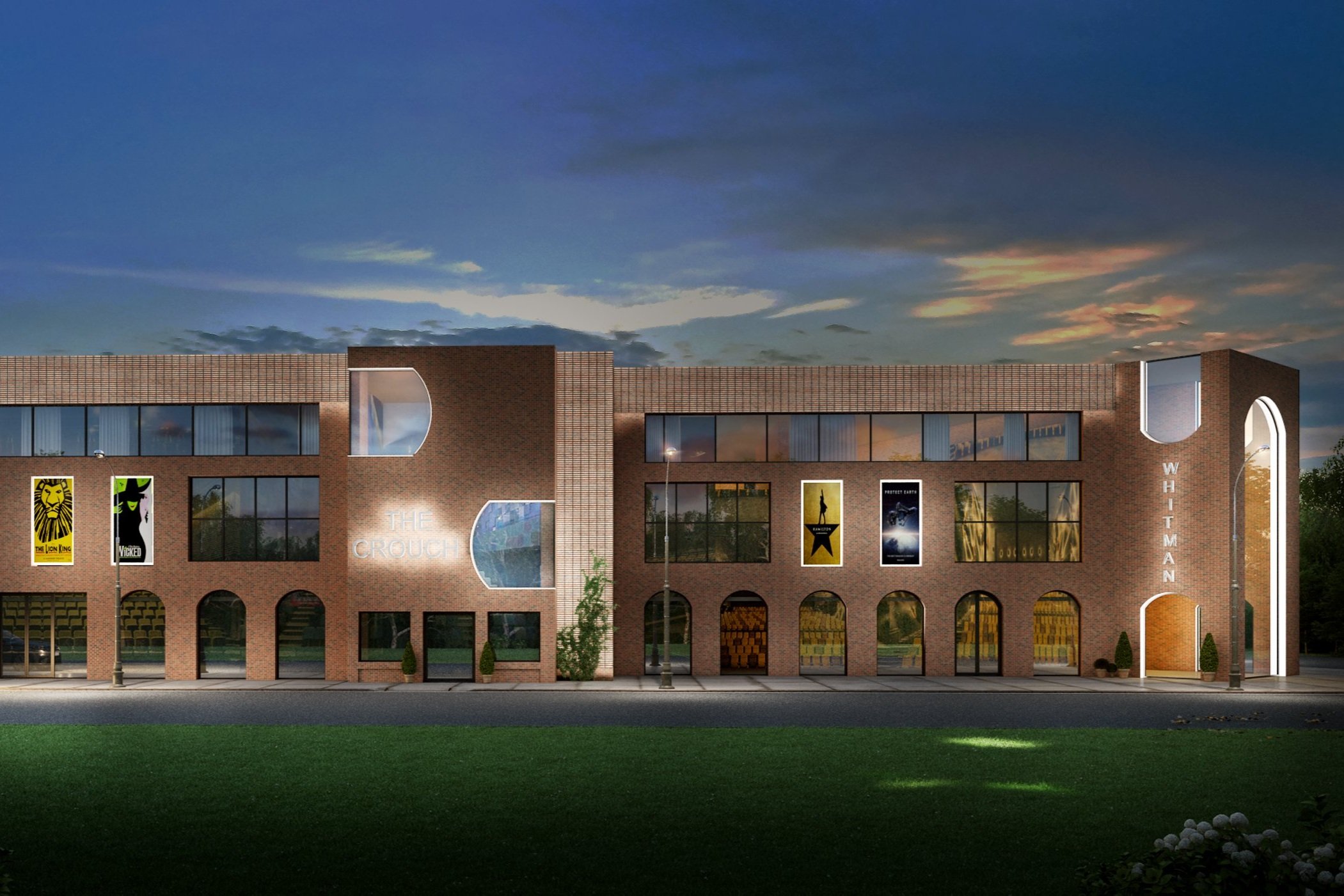 A modern brick commercial building with large windows, banners, and signage for 'The Crouch' and 'Whitman.' The sky is at dusk with colorful clouds, and there is a green lawn in the foreground.