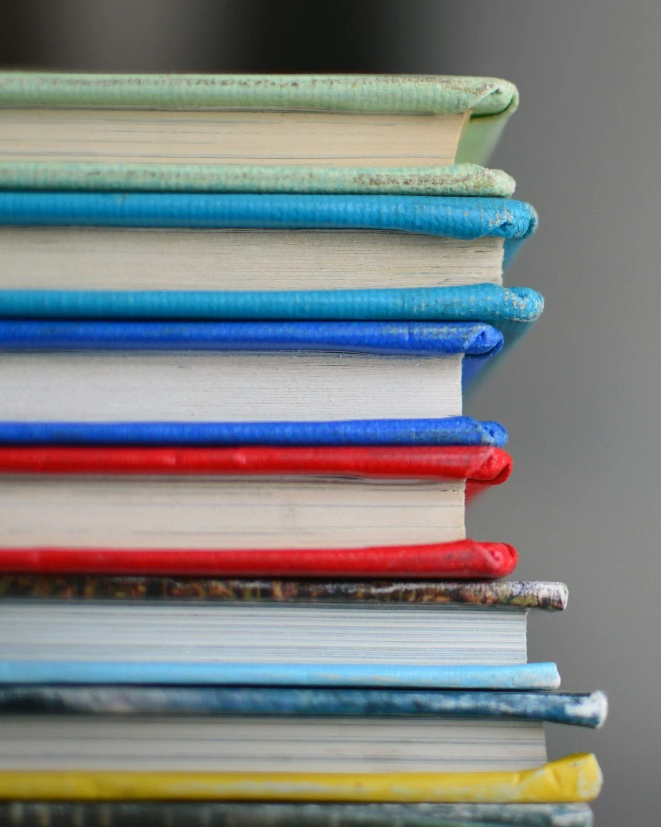 Stack of colorful hardcover books viewed from the side