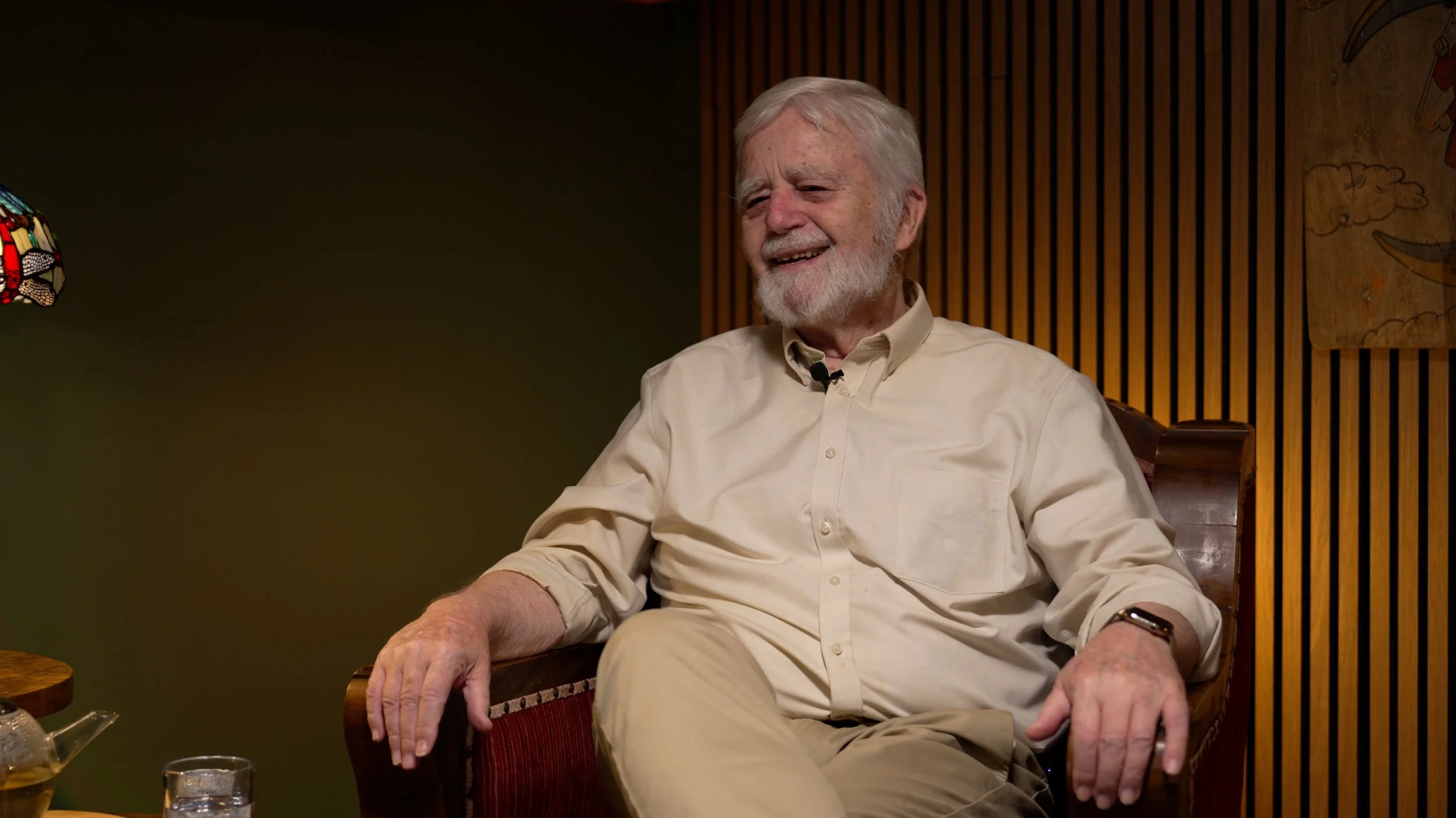 Elderly man with white hair and beard smiling during an on-camera legacy interview at Sound Legacy's San Rafael studio.