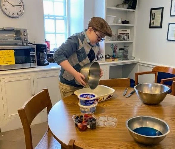 Teen holding a bowl pouring batter into a baking dish.