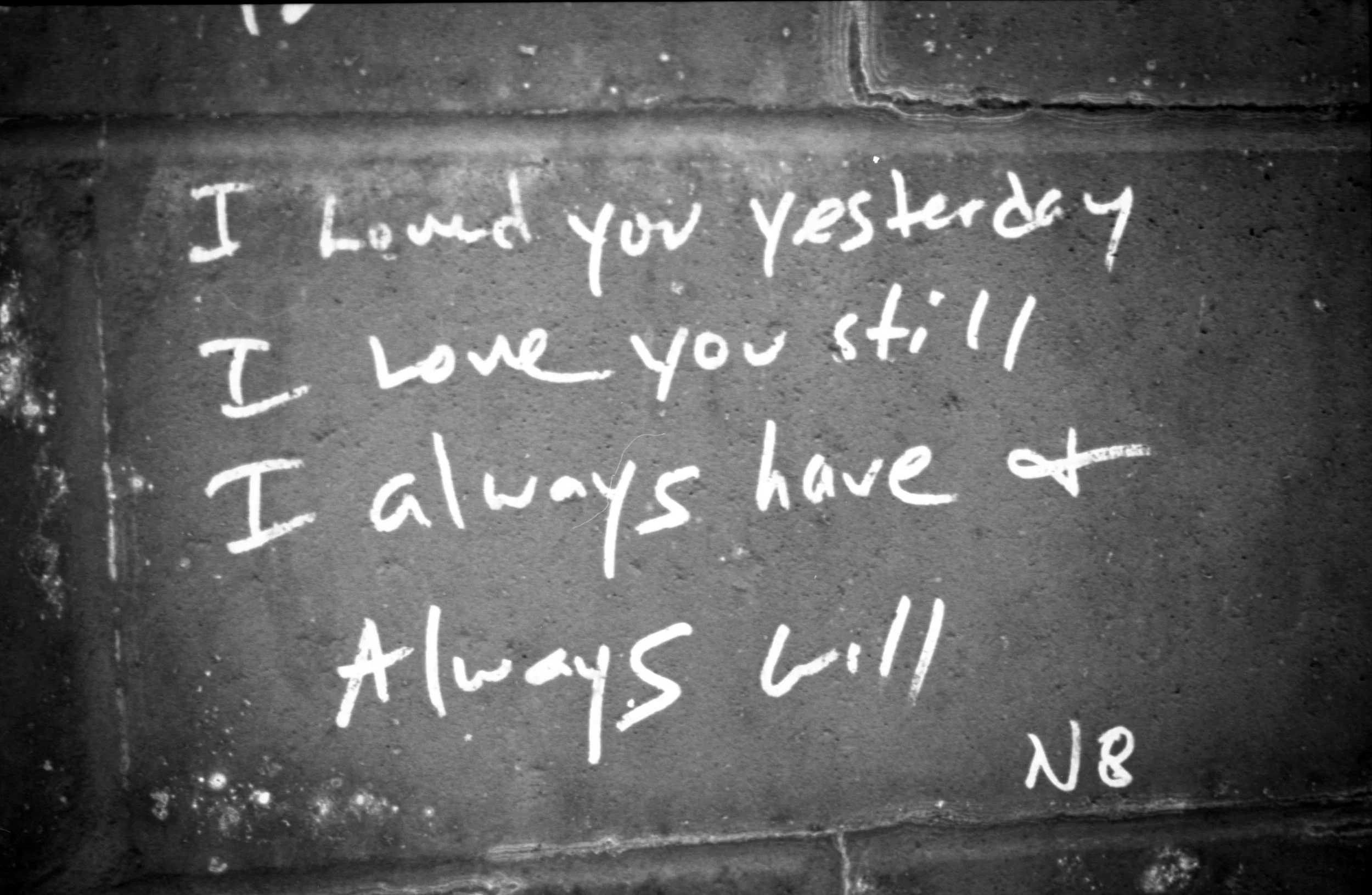 Chalk graffiti on a brick wall reading, "I loved you yesterday. I love you still. I always have and I always will."