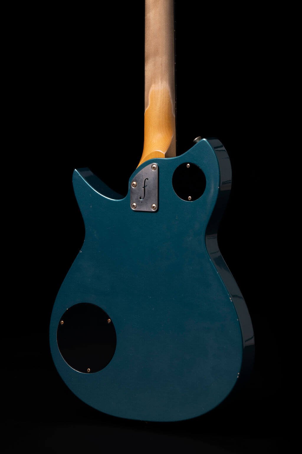 Closeup view of the back of an electric guitar in ocean turquoise