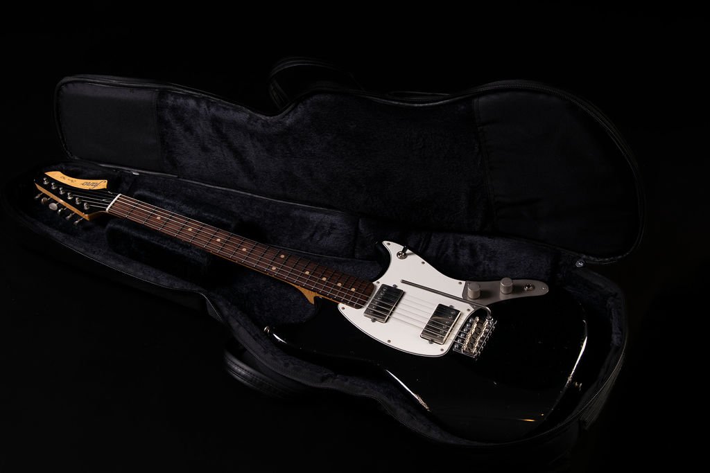 An electric guitar with bull black body in a soft Fano gig bag case with black velvet lining