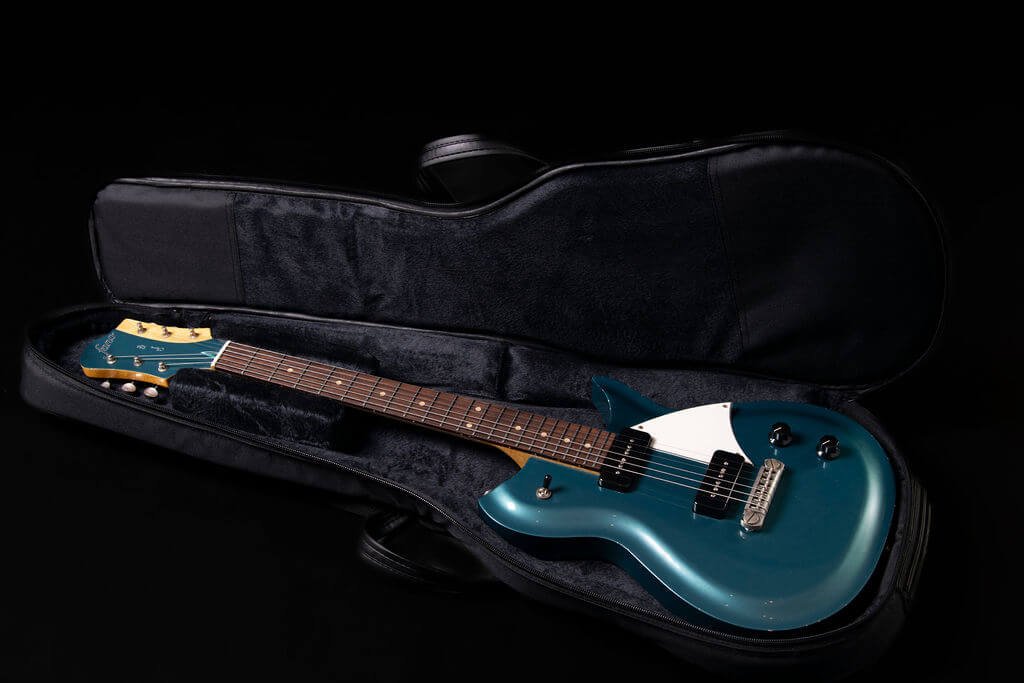 An electric guitar with an ocean turquoise body in a soft Fano gig bag case with black velvet lining