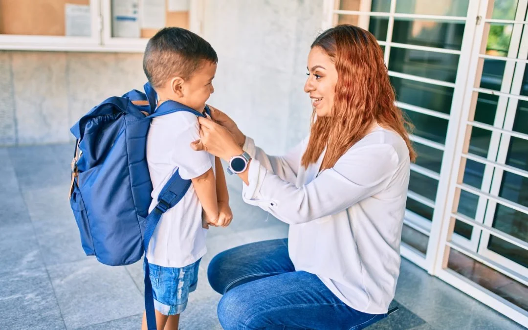 Teaher saying hi to a student with a backpack on