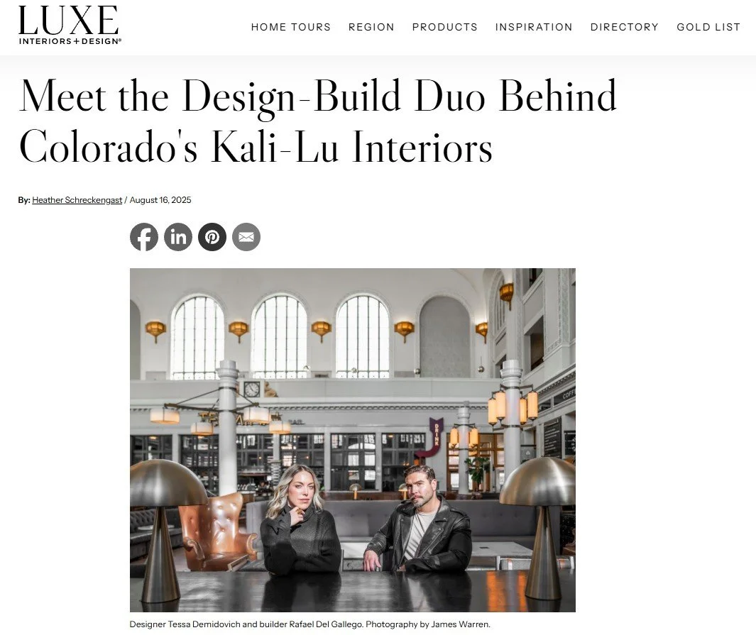 Photo of a modern, elegant interior with two people seated at a table, featuring large arched windows, white walls, and stylish lighting fixtures.