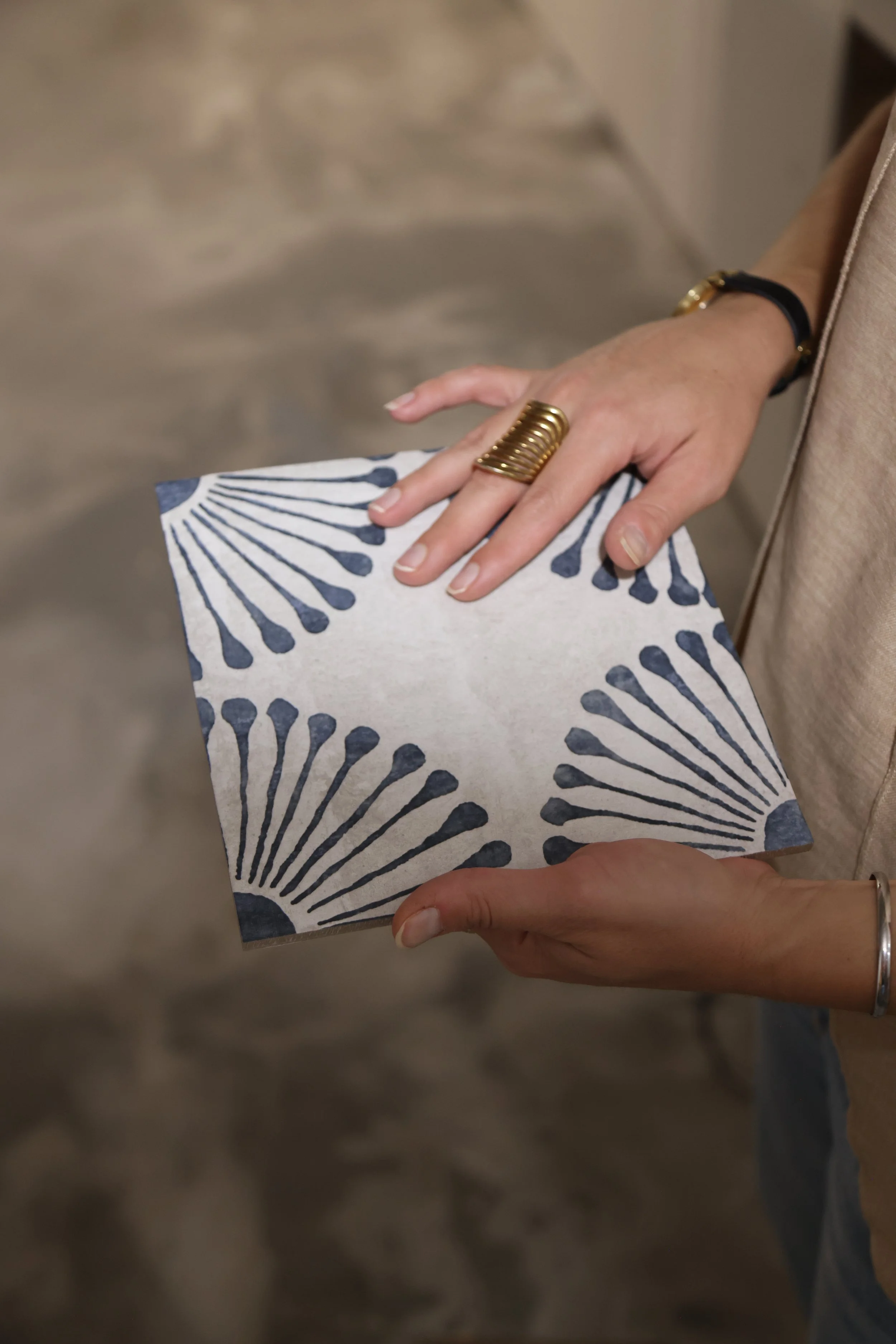 hands holding white and blue tile sample